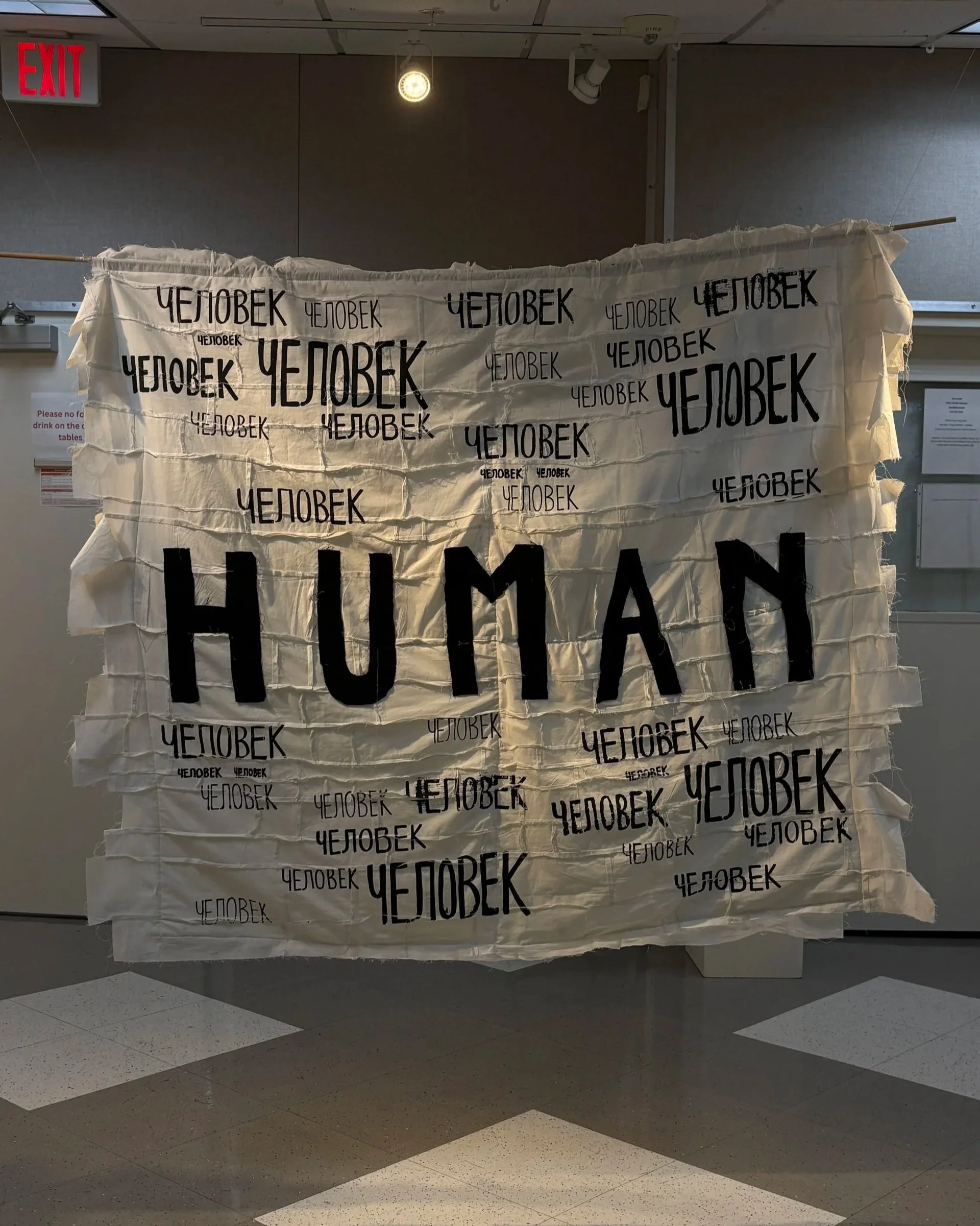 Alexis Fredericks, HUMAN., double-sided quilt installation examining memory, identity, and inherited histories through screen printing and appliqué. Side 1: English