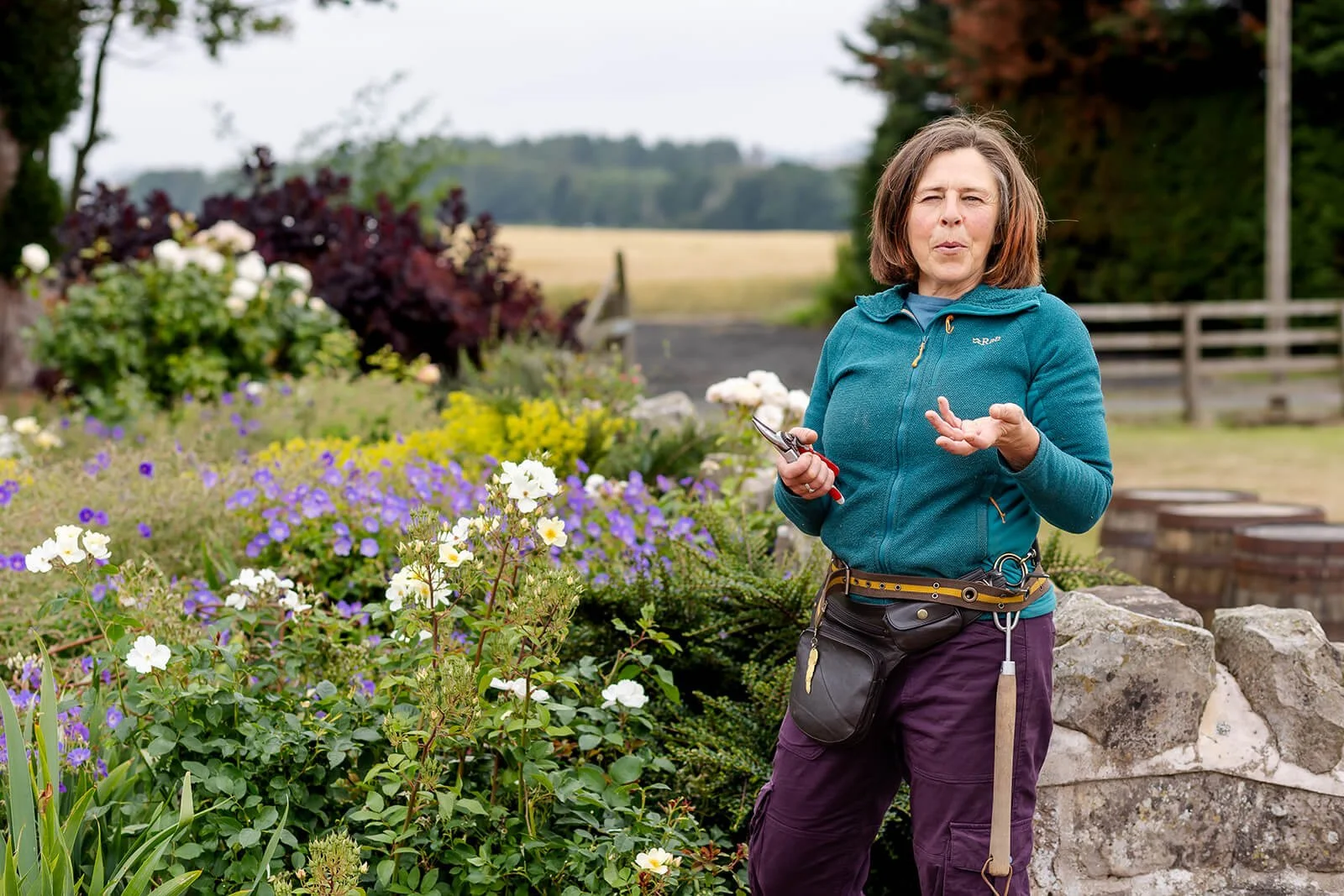 Clare in a large garden explaining with cutters