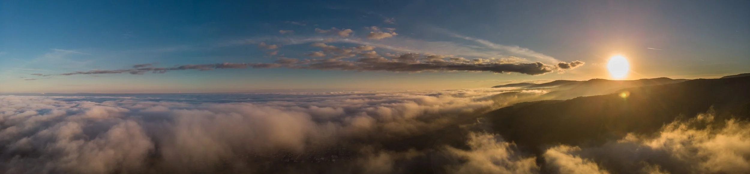 A panoramic view of a sunset over mountains and clouds in the sky representing executive presence and legacy.