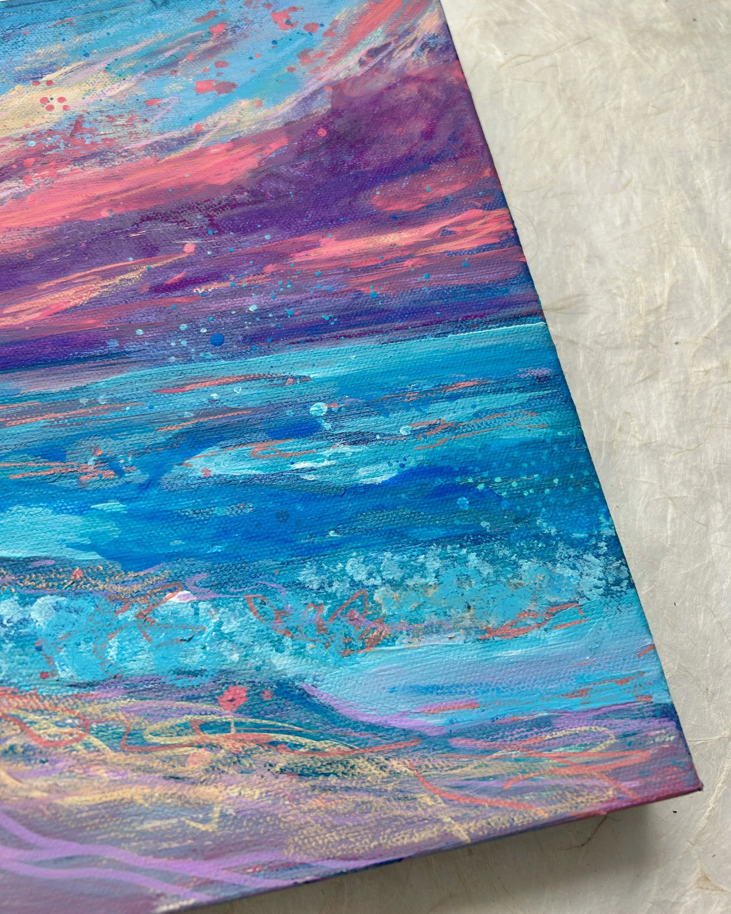 Close-up of an abstract painting with shades of blue, purple, pink, and orange, featuring brushstrokes and splatters on canvas.