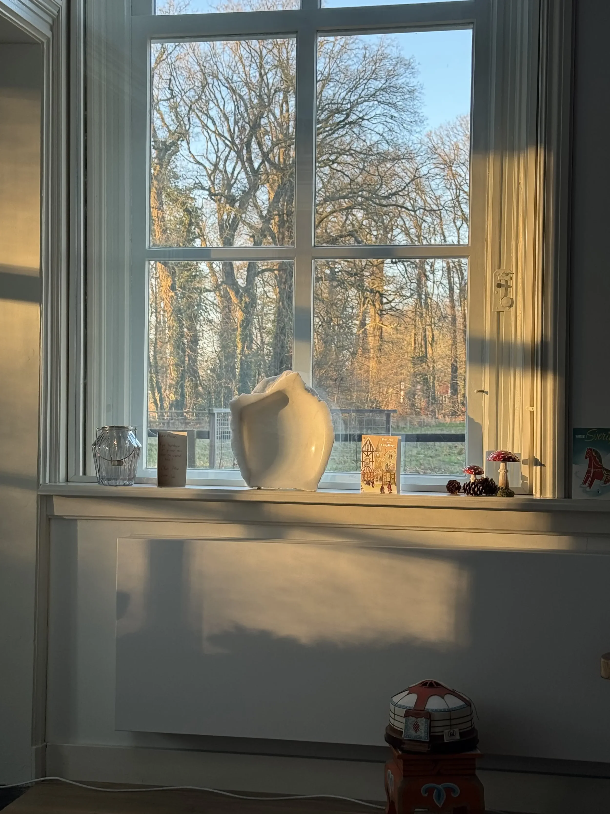 Beeld Transparantie van wit albast staand in vensterbank