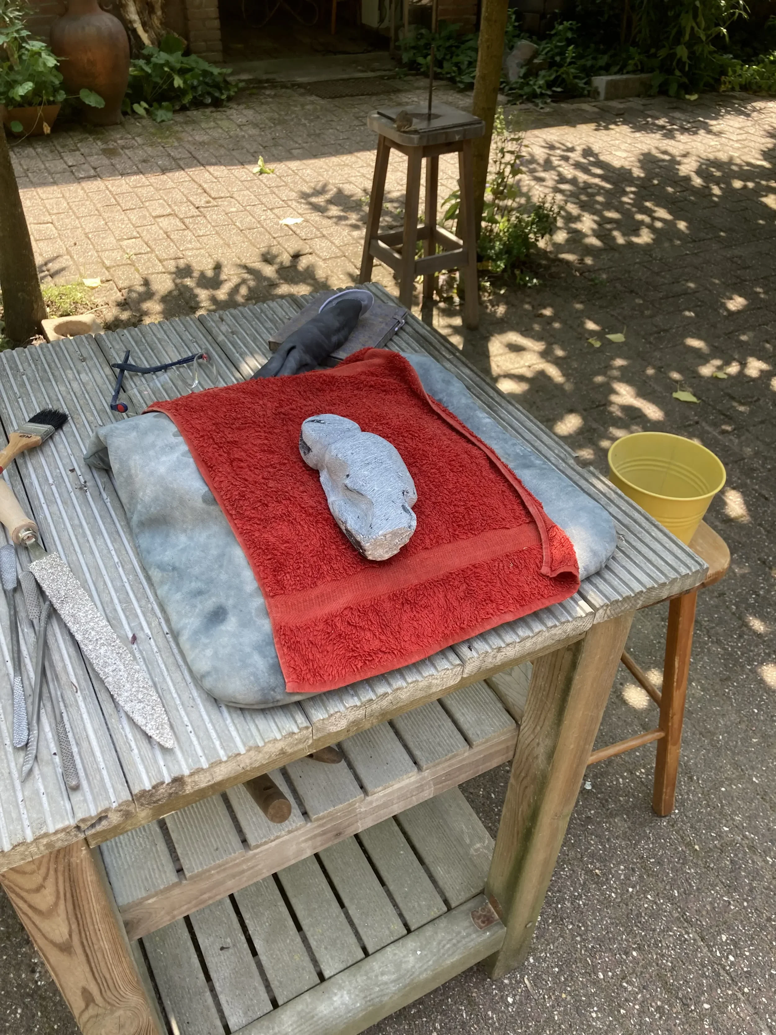 Het beeld Denken ligt op de beeldhouwbok tijdens het maken.
