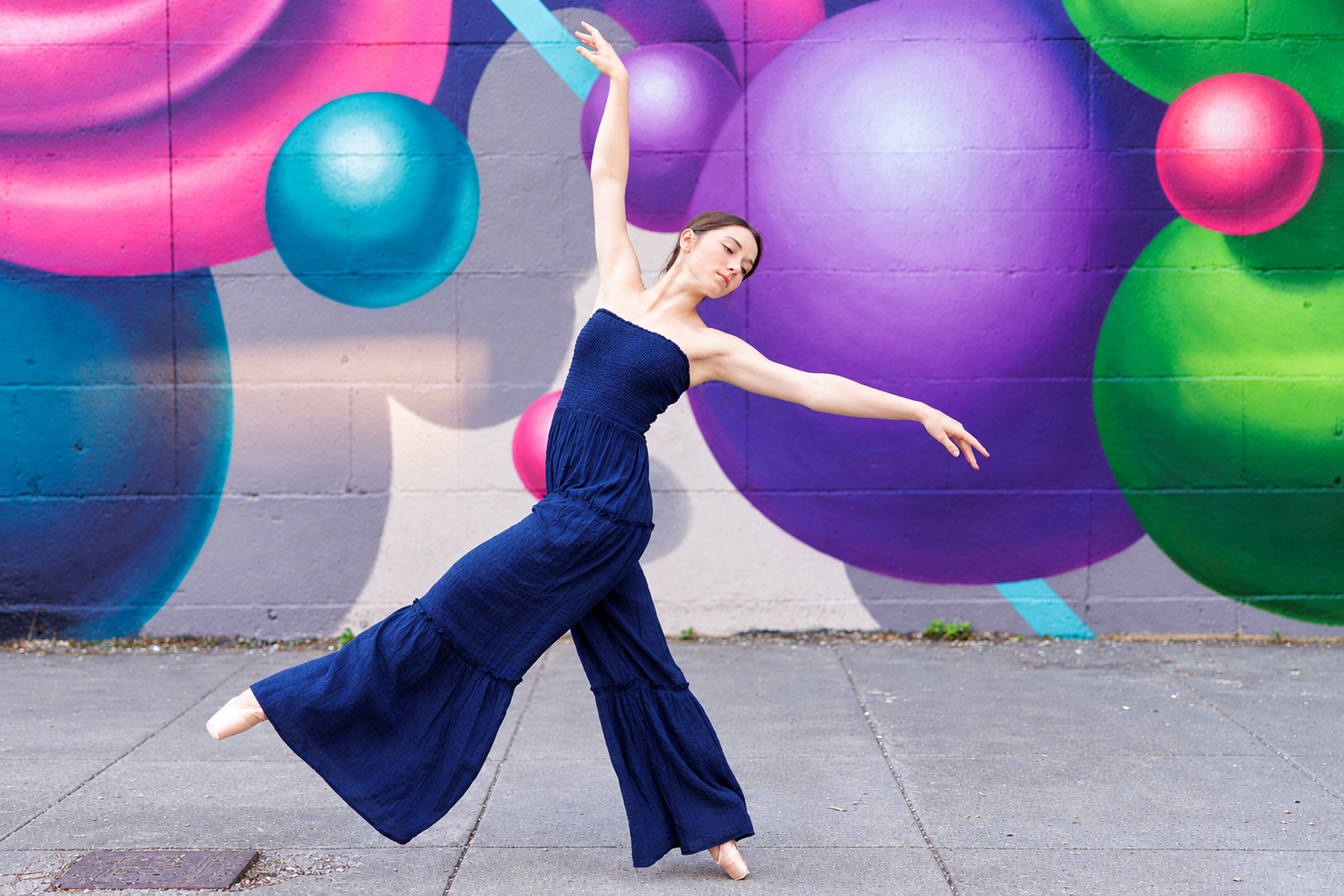 Ballet Arabesque Against Vibrant Mural.png
