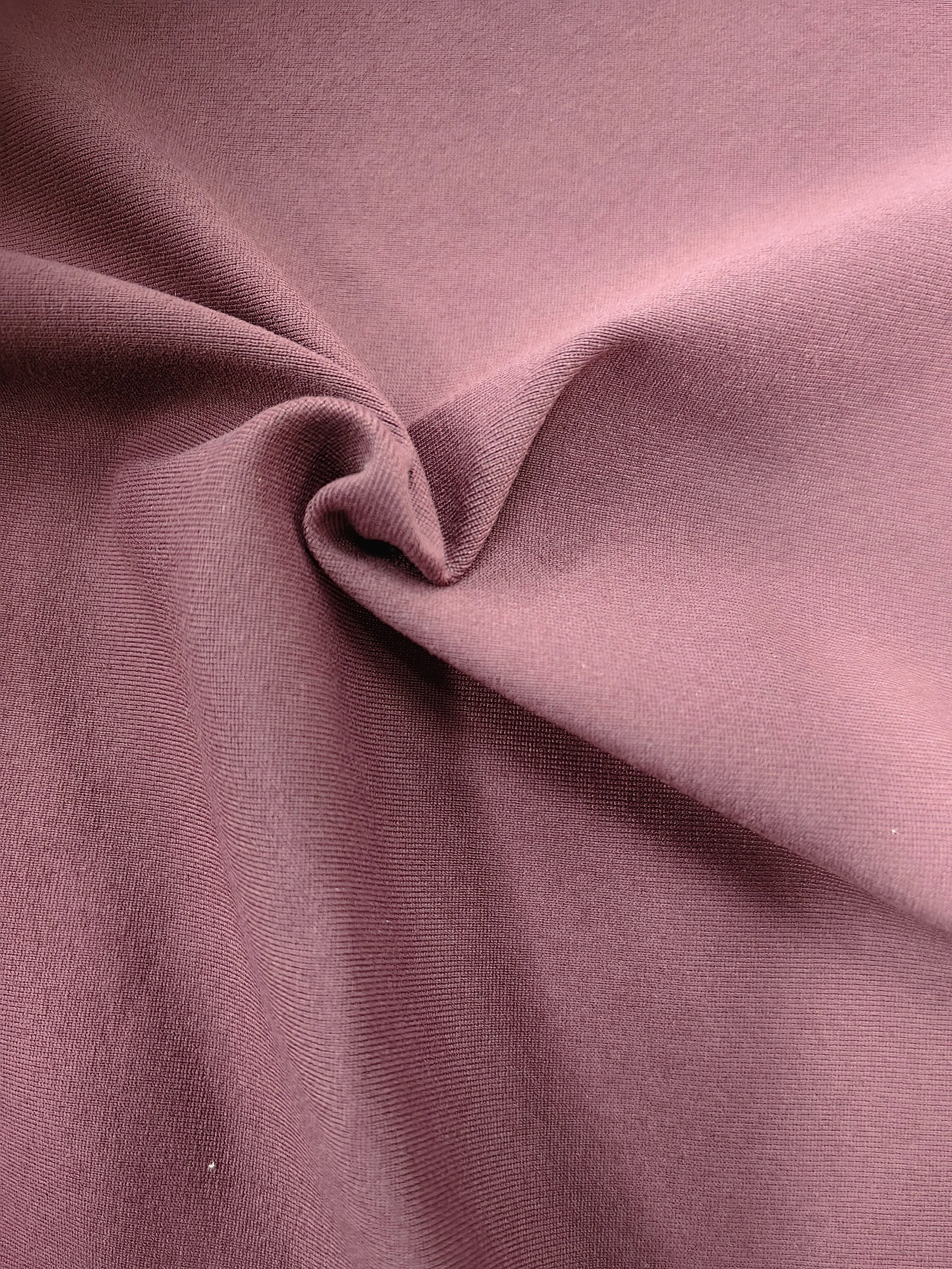 Close-up of pink fabric with a textured surface and a small fold.