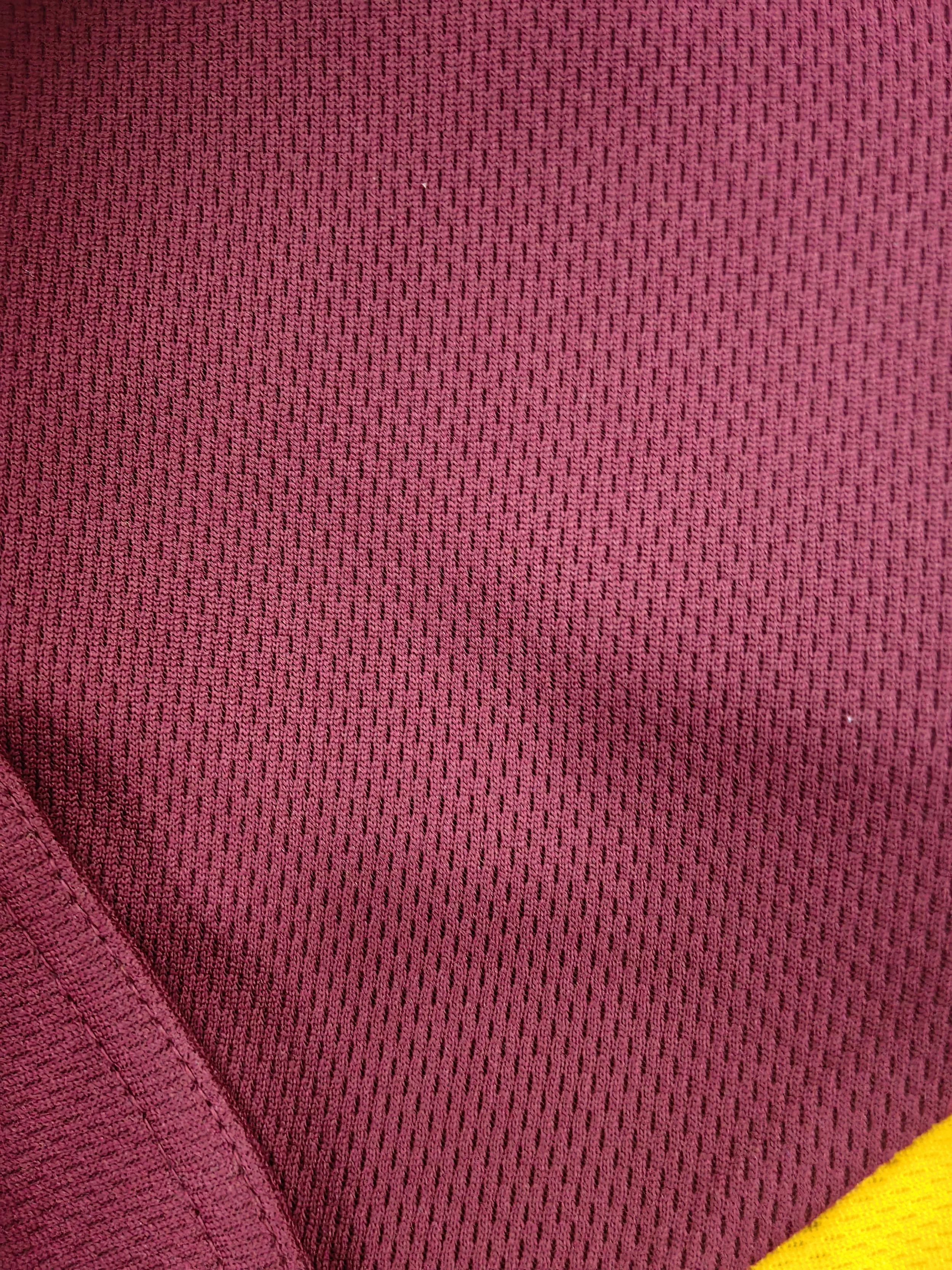 Close-up of pink textured fabric with yellow edge in the bottom right corner.