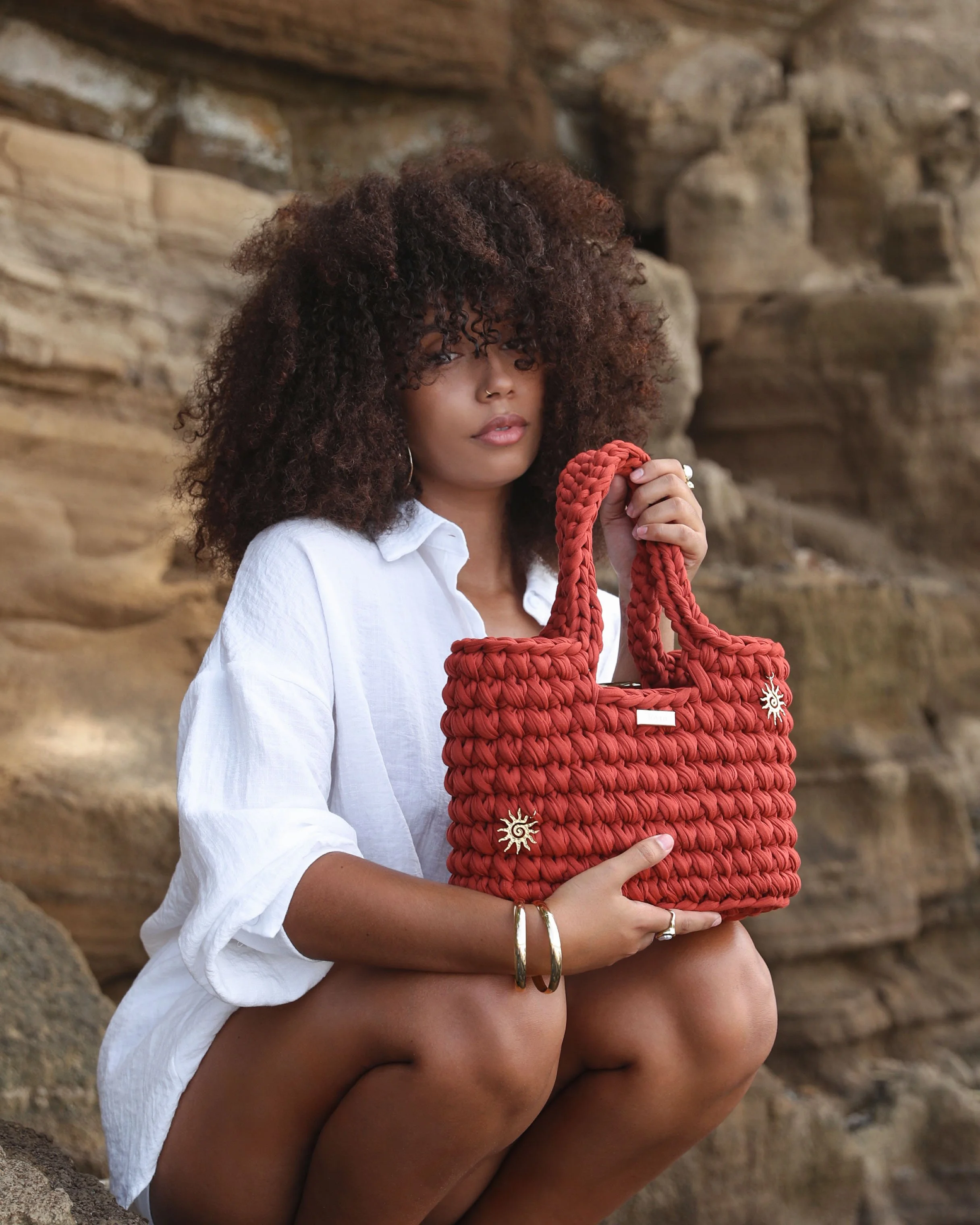 Sac à main Joy en crochet terracotta, entièrement confectionné à la main par Joyra, porté par une femme.