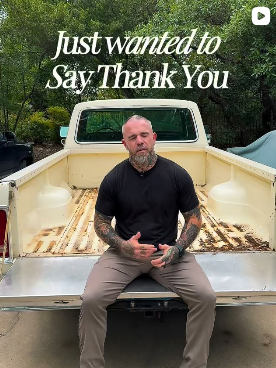 Man sitting on the tailgate of a pickup truck with trees in the background, wearing a black shirt and beige pants, with the text "Just wanted to Say Thank You" above.