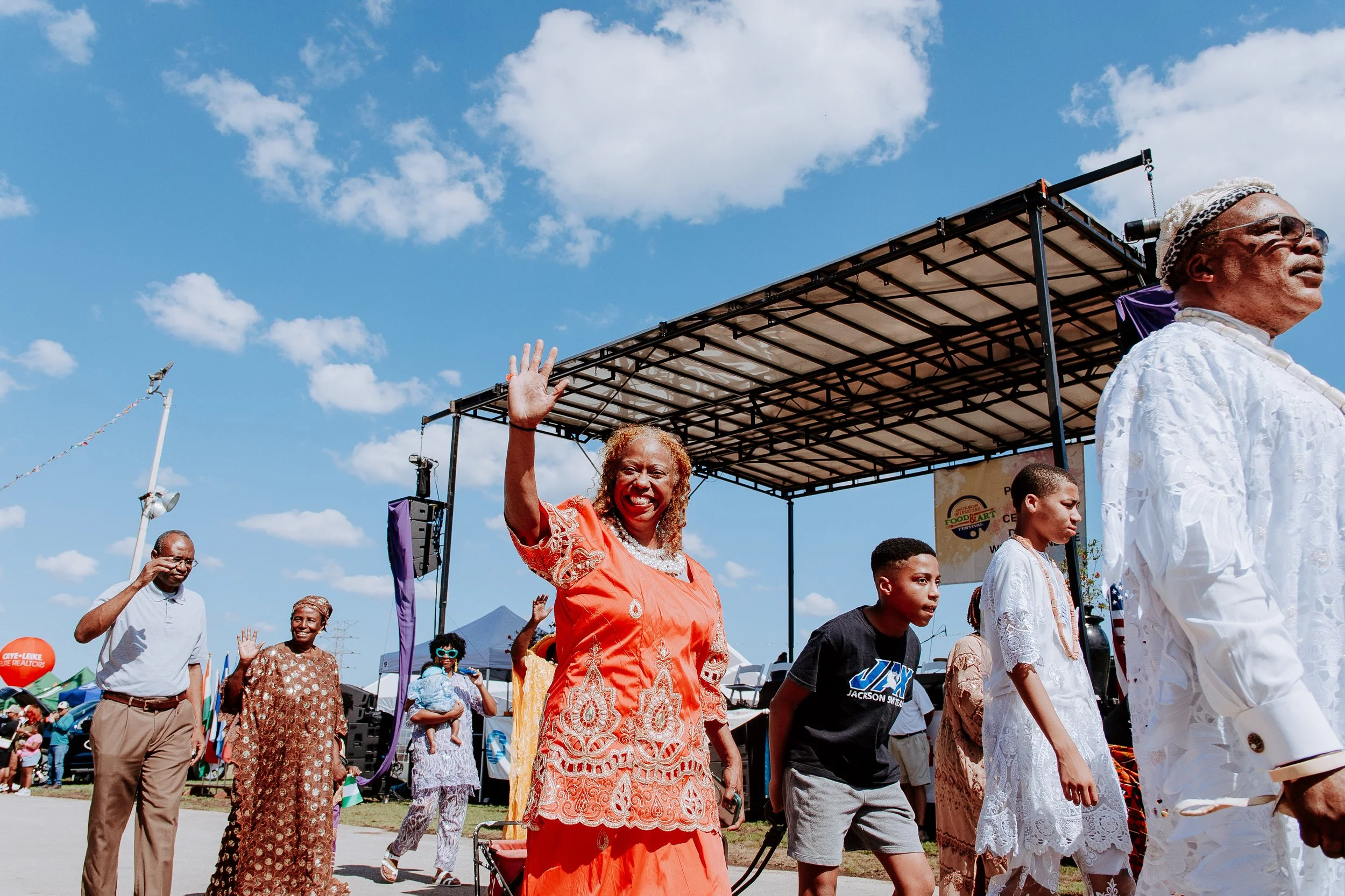 african lady waving at camera in parade (H).jpg