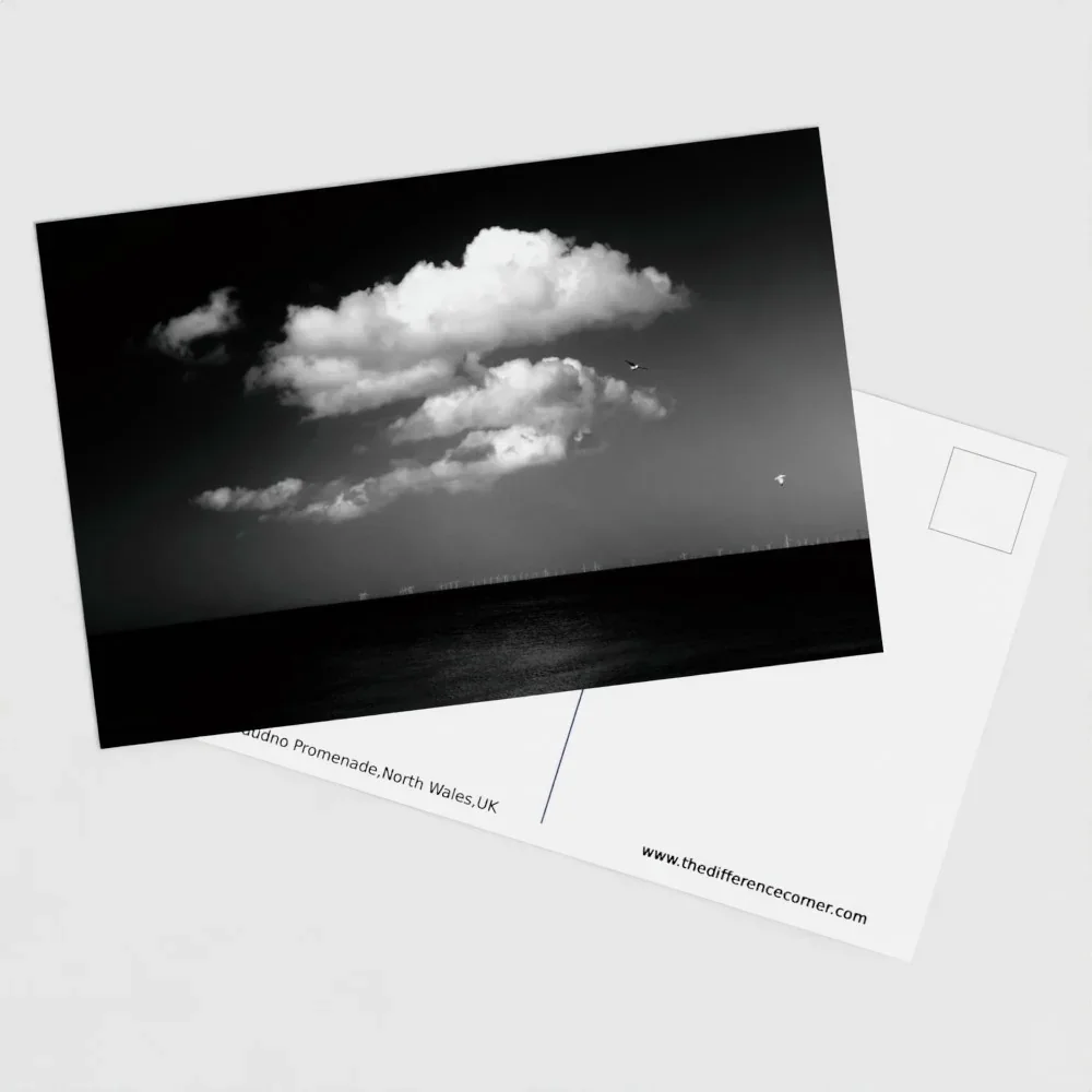Black and white photograph of Llandudno Promenade on the North Wales coast, with sea, clouds and Victorian shoreline, fine art postcard
