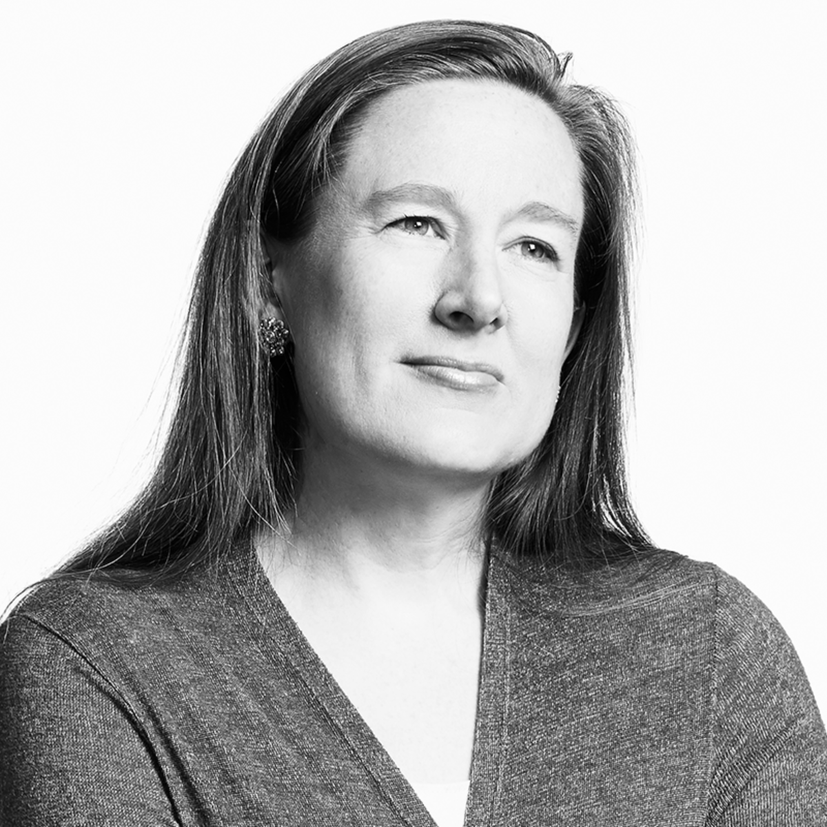 Black and white portrait of a woman with long hair, wearing earrings and a textured top, looking slightly to the side with a contemplative expression.