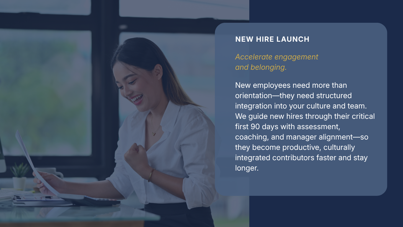 A woman smiling and celebrating with a clenched fist while working at a desk with a laptop and notebooks, near a large window, during a presentation about a new hire launch.