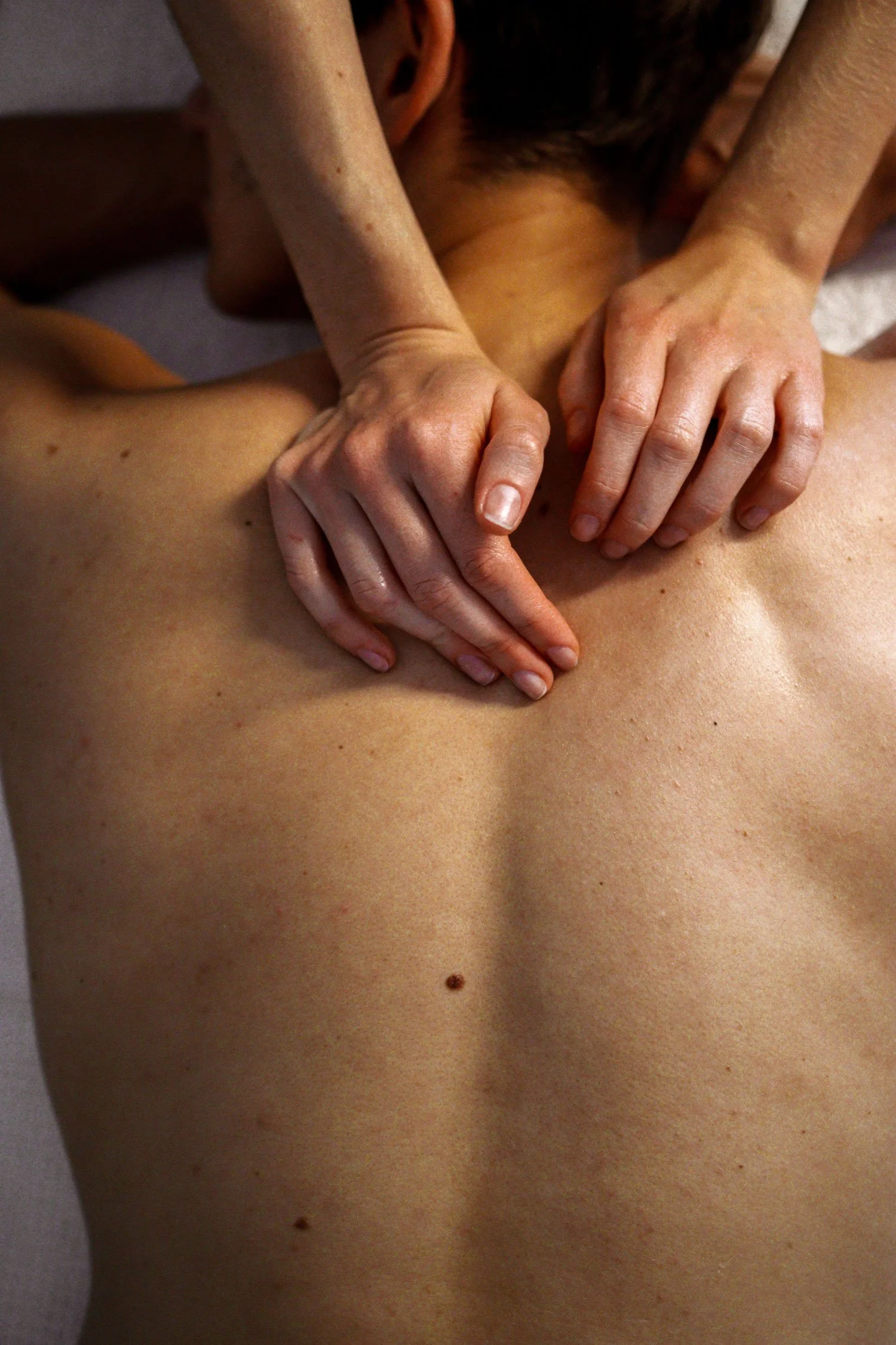 Une personne recevant un massage, centré sur bras et torse nue.