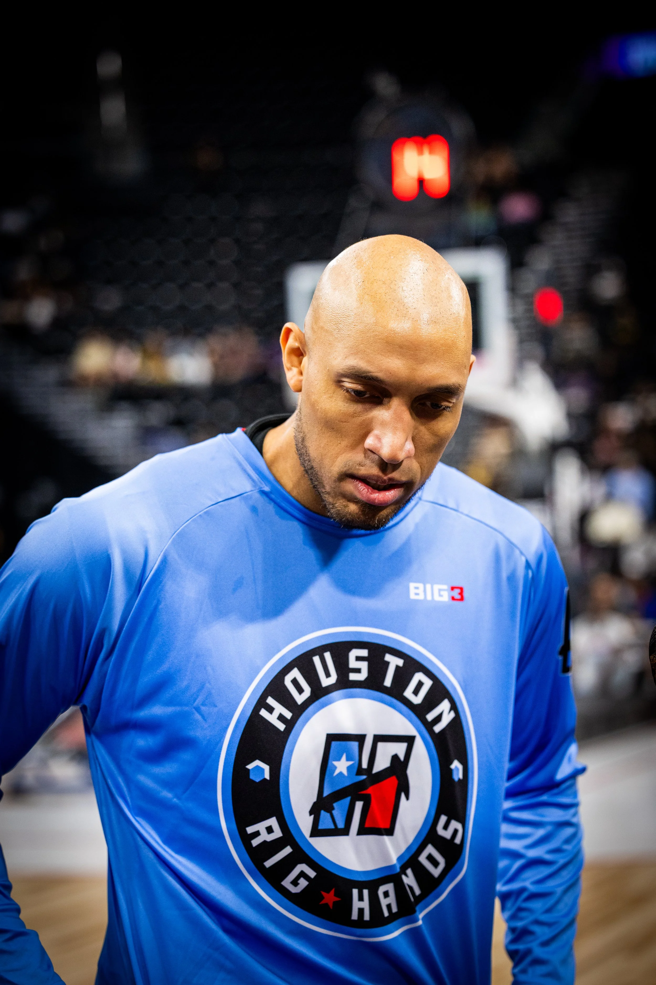 A bald man wearing a blue Houston Righands jersey with a round logo