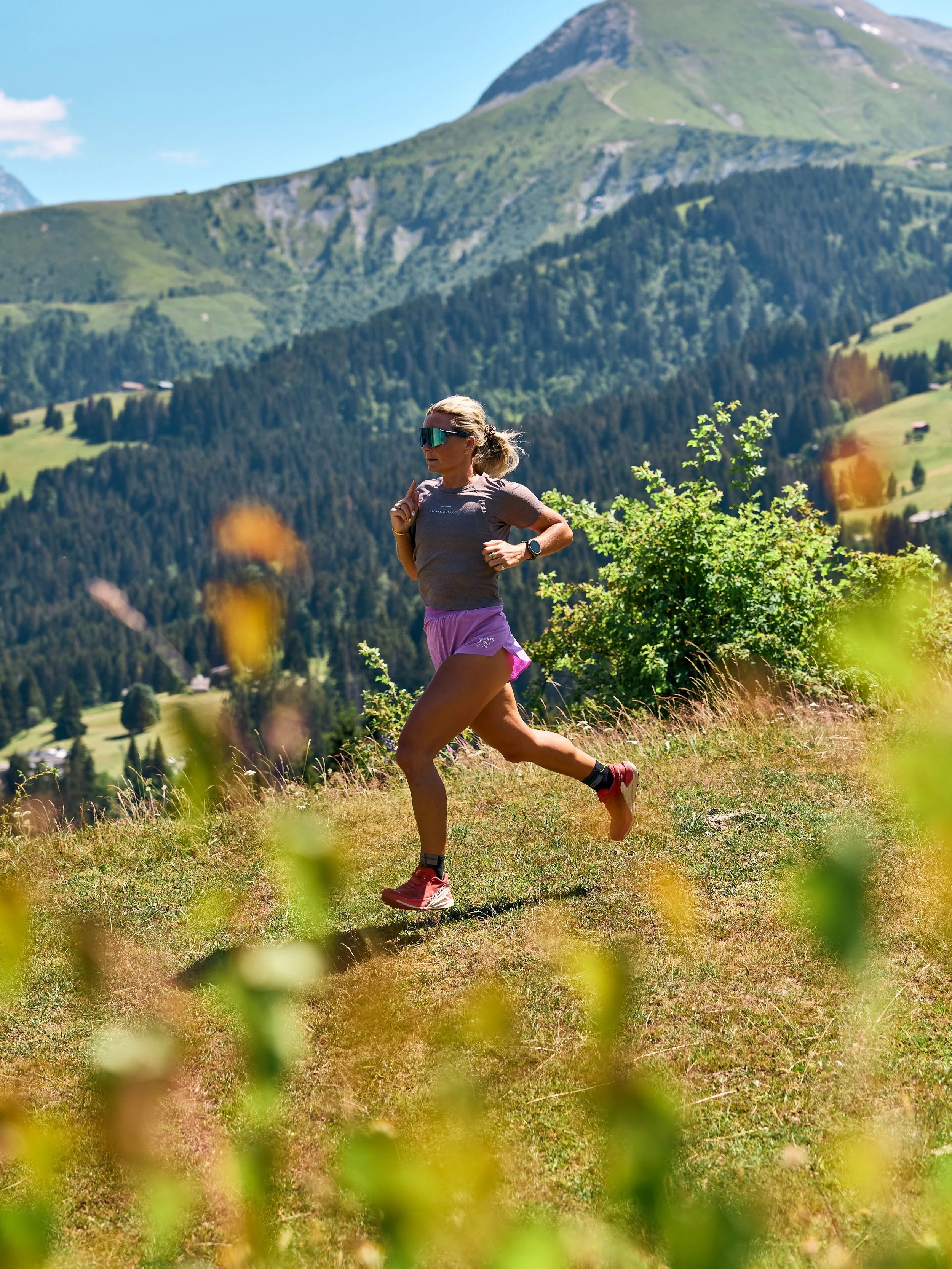 Imo running on grass with mountains in the background