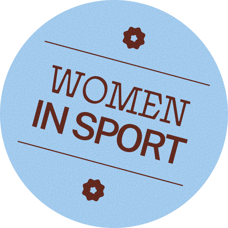 A circular badge with a light blue background and brown text that reads 'Women in Sport', decorated with small flower symbols at the top and bottom.