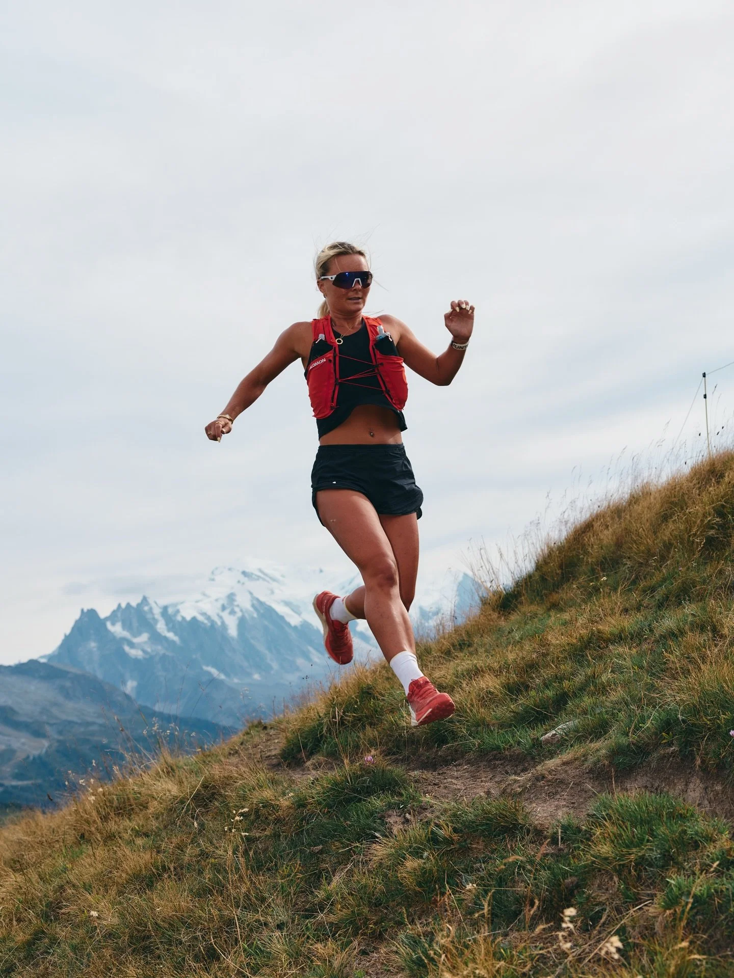 Imo wearing red and black running kit with a mountain in the background.