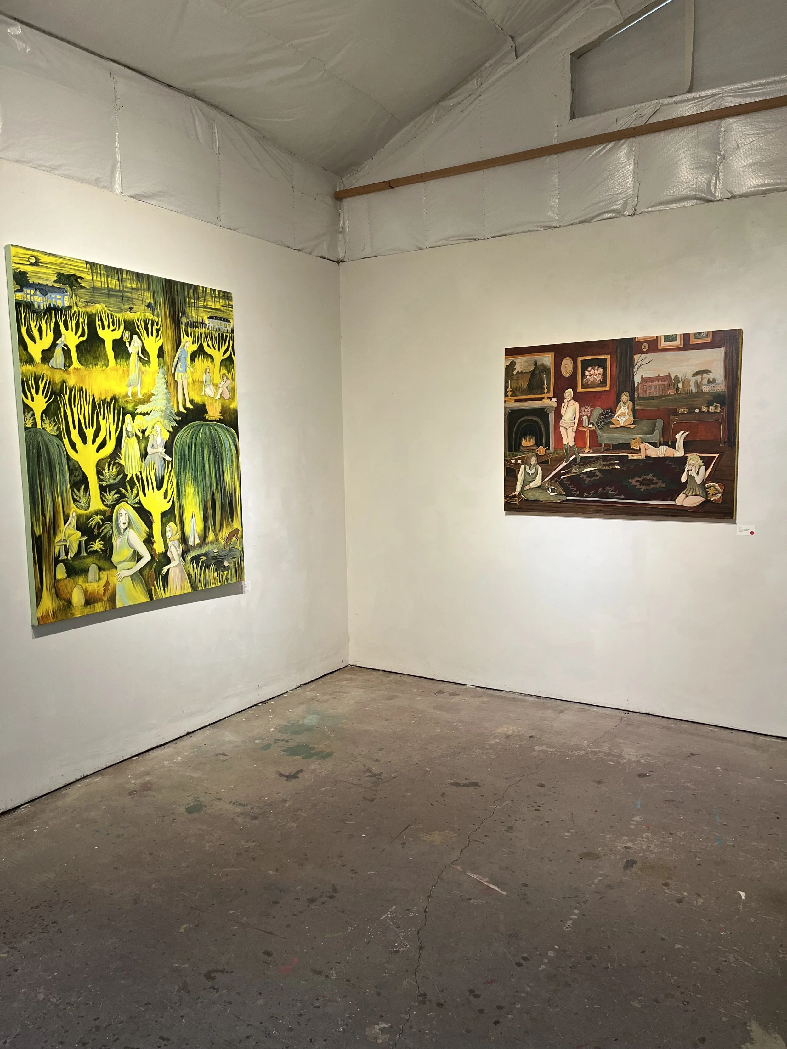 Photo of an art gallery interior with two paintings on white walls. The floor is concrete and appears worn.