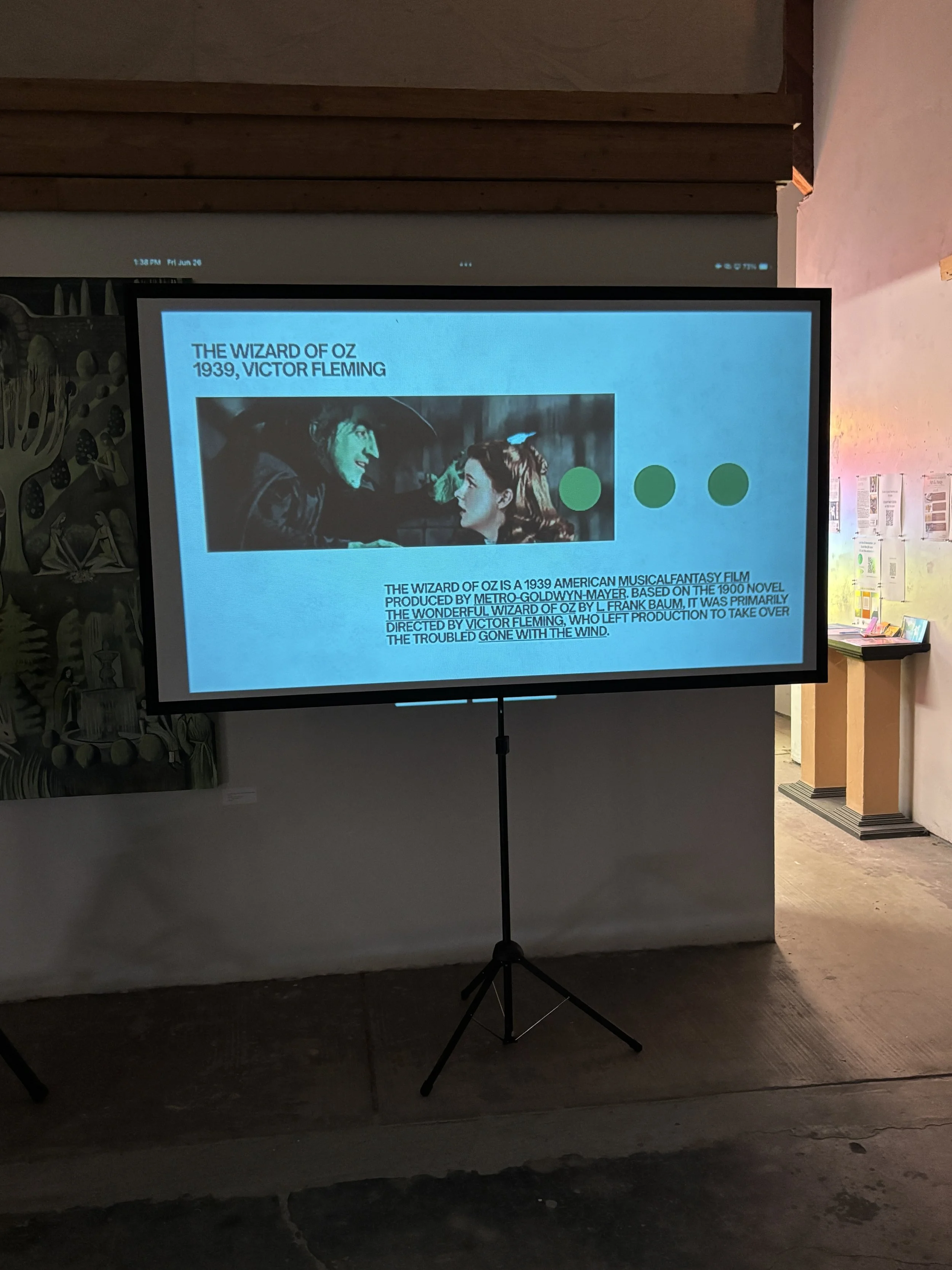 A presentation slide about the 1939 film "The Wizard of Oz" showing a scene with characters from the film and descriptive text.