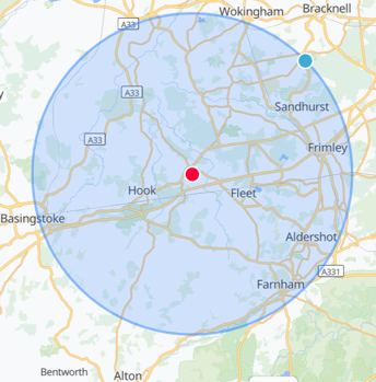 Map showing a blue circle centered near Fleet, with nearby towns such as Sandhurst, Frimley, and Aldershot in England.