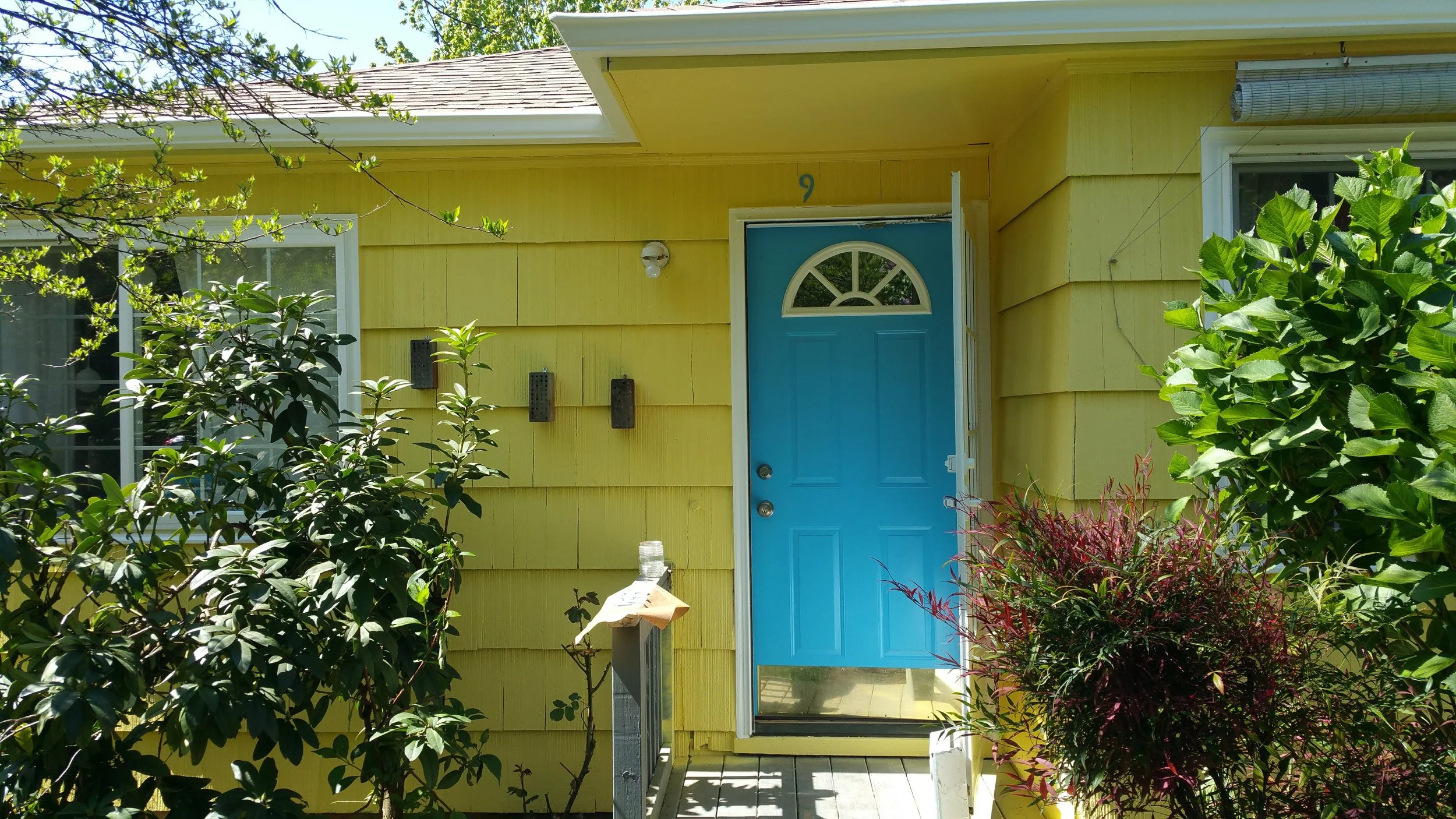 picture of a front door and house with a charming yellow, blue and cream color scheme