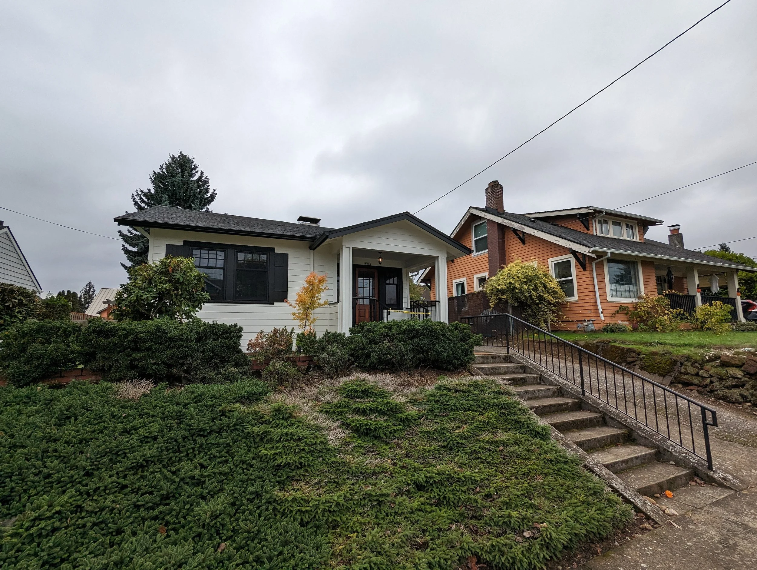 picture of a freshly painted white and black house under cloudy skies