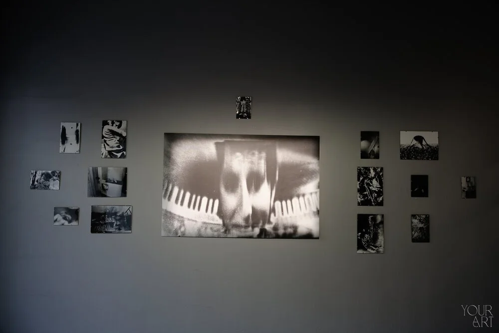Black and white art gallery wall with a large central photo and multiple smaller photos spread around it.