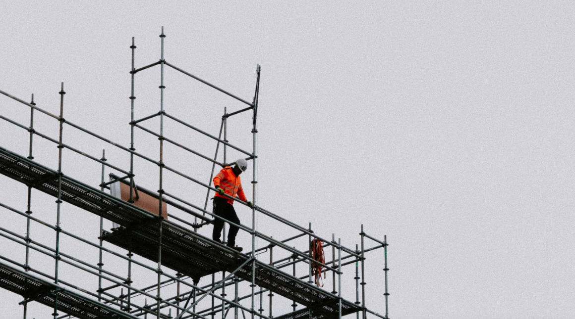 Worker in hard hard looking over construction scaffolding