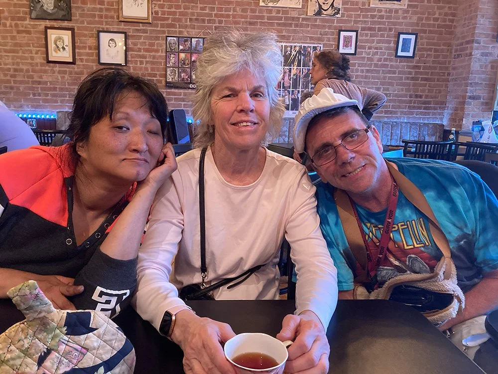 3 individuals sitting and posing for a photo