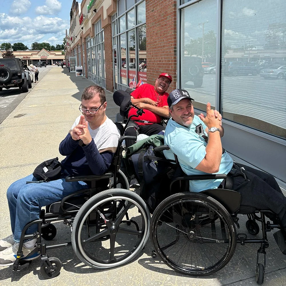 3 individuals sitting and laughing while posing for a photo