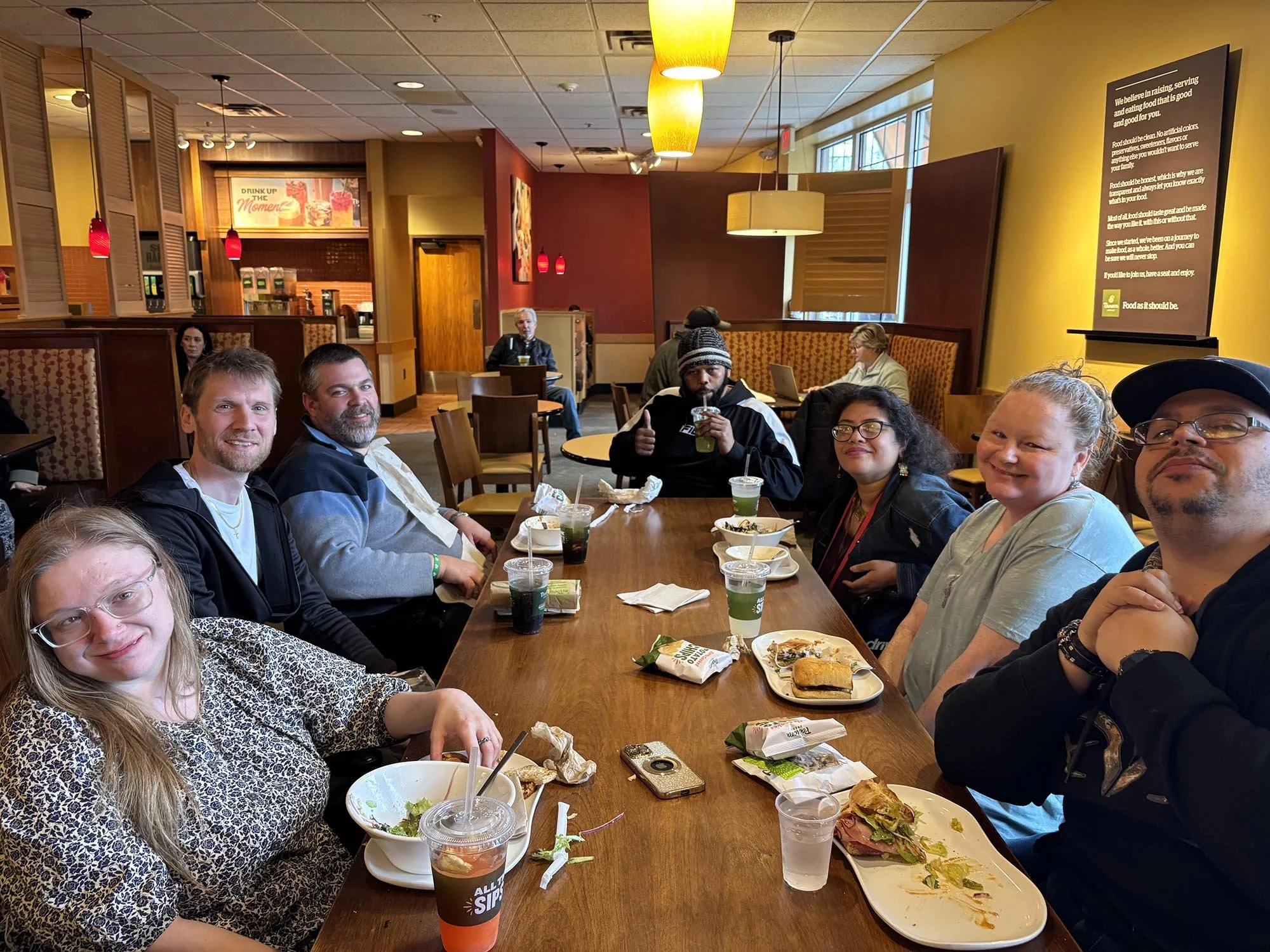 A group of 7 people having lunch at a long table