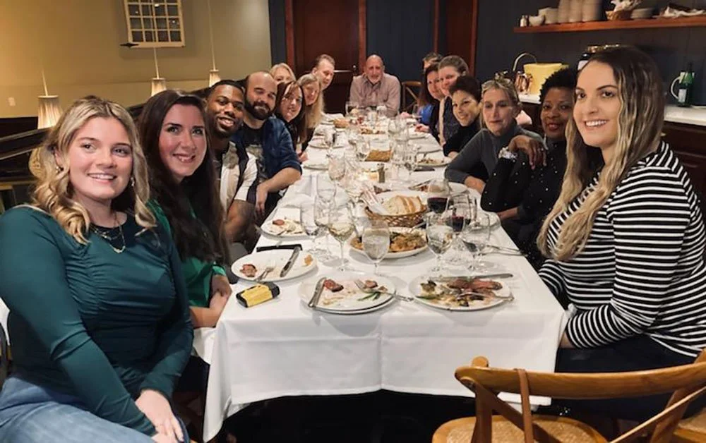 Group of individuals enjoying dinner at a table