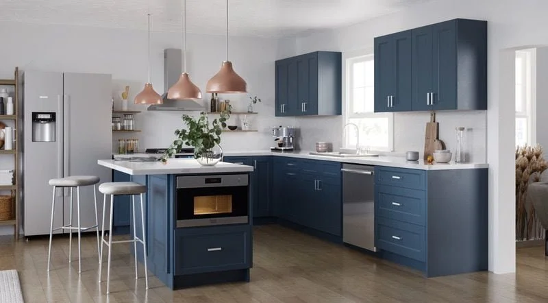 Modern kitchen with blue cabinets, white countertops, stainless steel appliances, and pendant lights over a small island with bar stools.