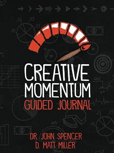 Cover of a journal titled 'Creative Momentum Guided Journal' by Dr. John Spencer and D. Matt Miller, featuring a speedometer-like graphic with red and white segments, set against a black background with scientific and mathematical sketches.
