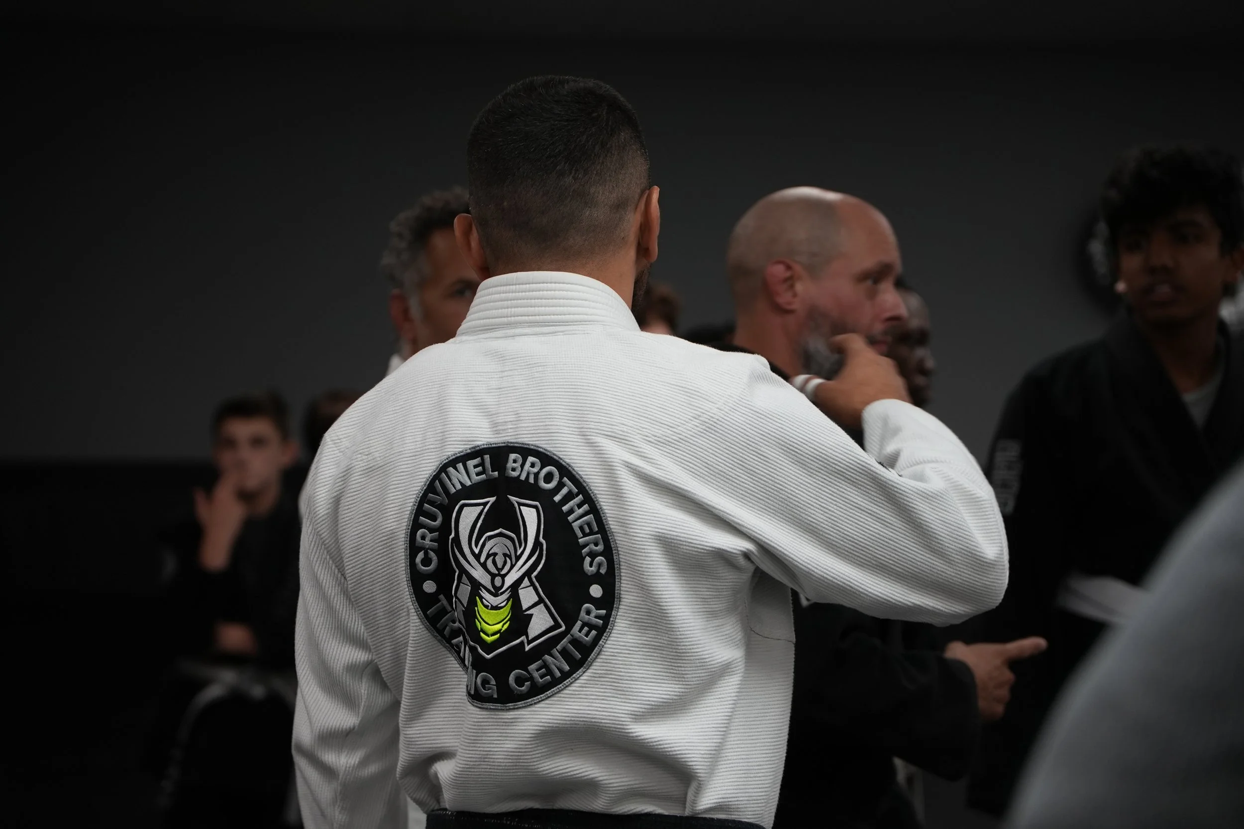Martial arts students in gis attending class in a dojo.