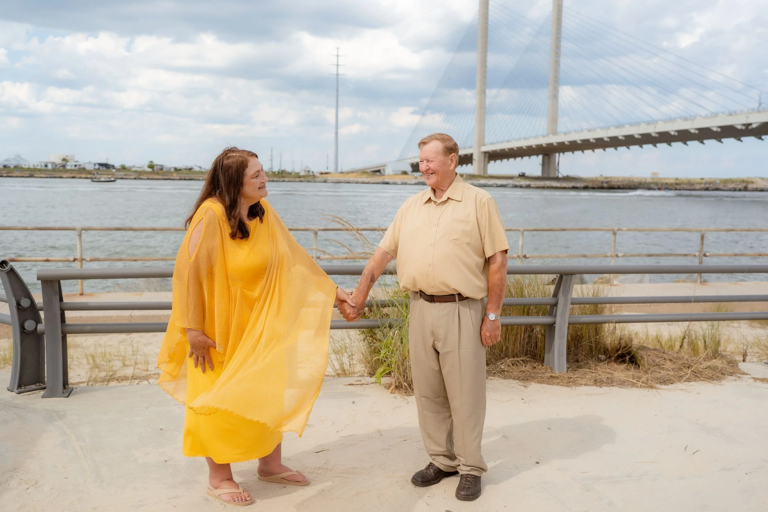 Couple celebrates their vow renewal on the waterfront at Indian River Inlet with the bridge in the background.