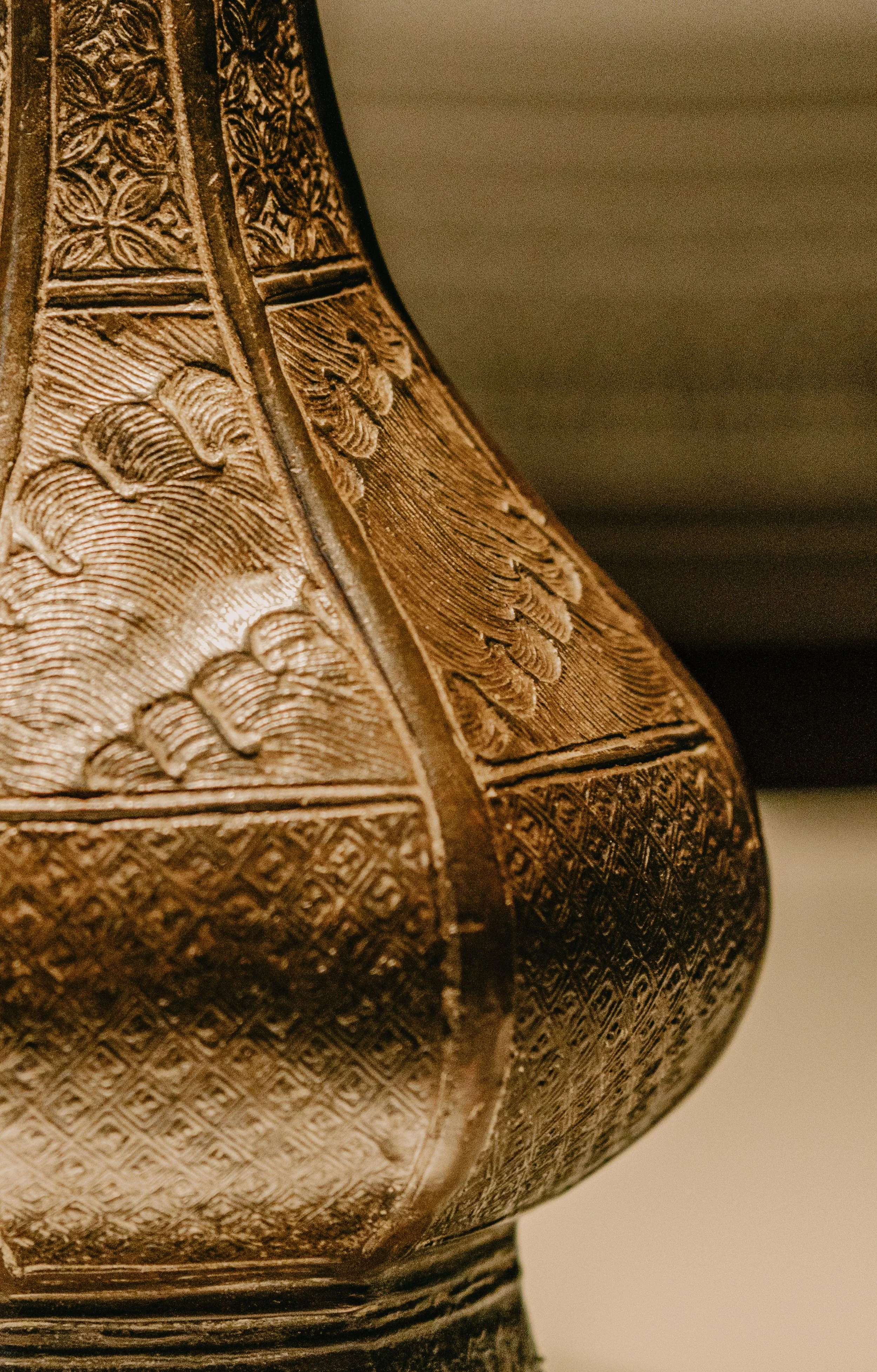 Close up view of ornate gold brass vessel with intricate detailing