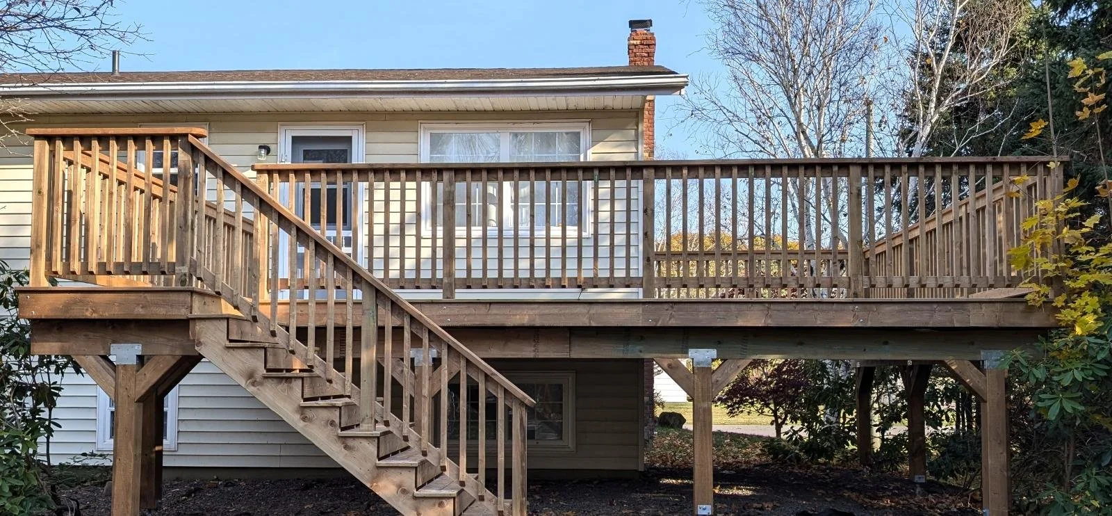 Custom designed and built pressure treated wood railings on upper deck built for homeowner in Stratford, PEI.