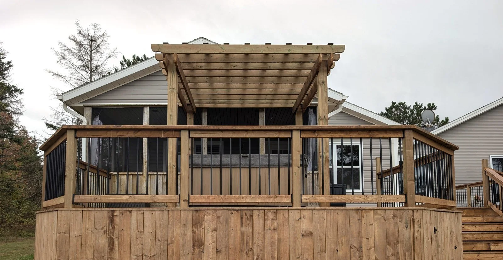 Custom designed and built pressure treated wood and black aluminum railings on multi level deck built for home owner in West Covehead, PEI.