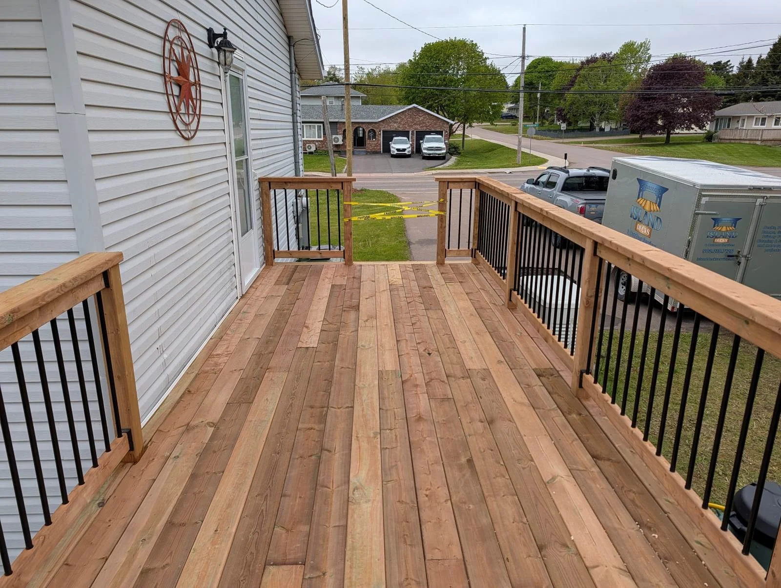 Custom designed and built pressure treated wood and black aluminum railings on deck built for home owner in Charlottetown, PEI.