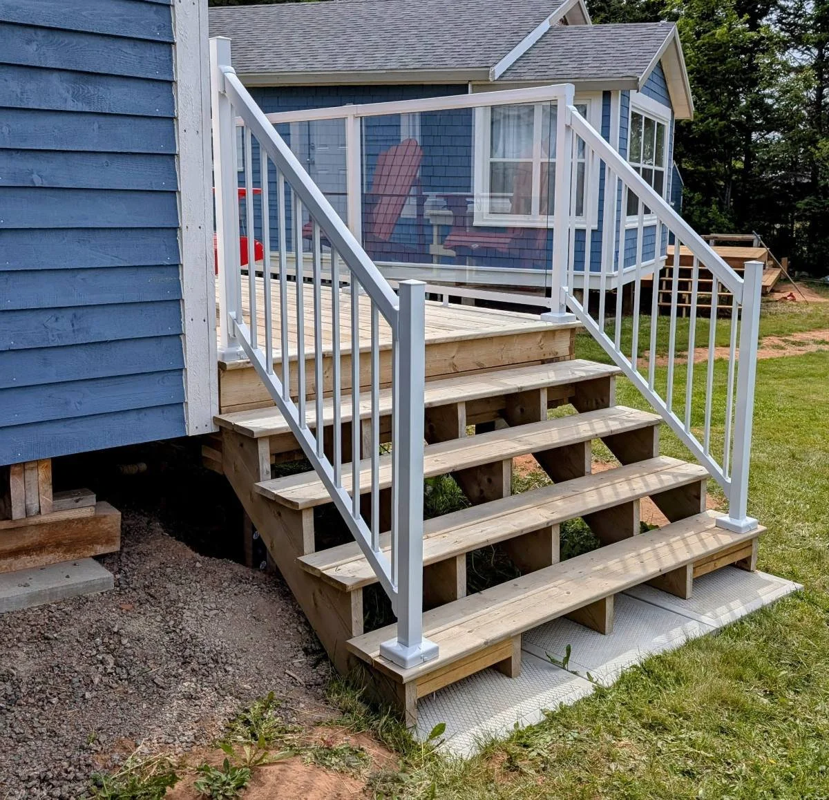 Custom designed and built glass and white aluminum railings for cottage owner in Long River, PEI.