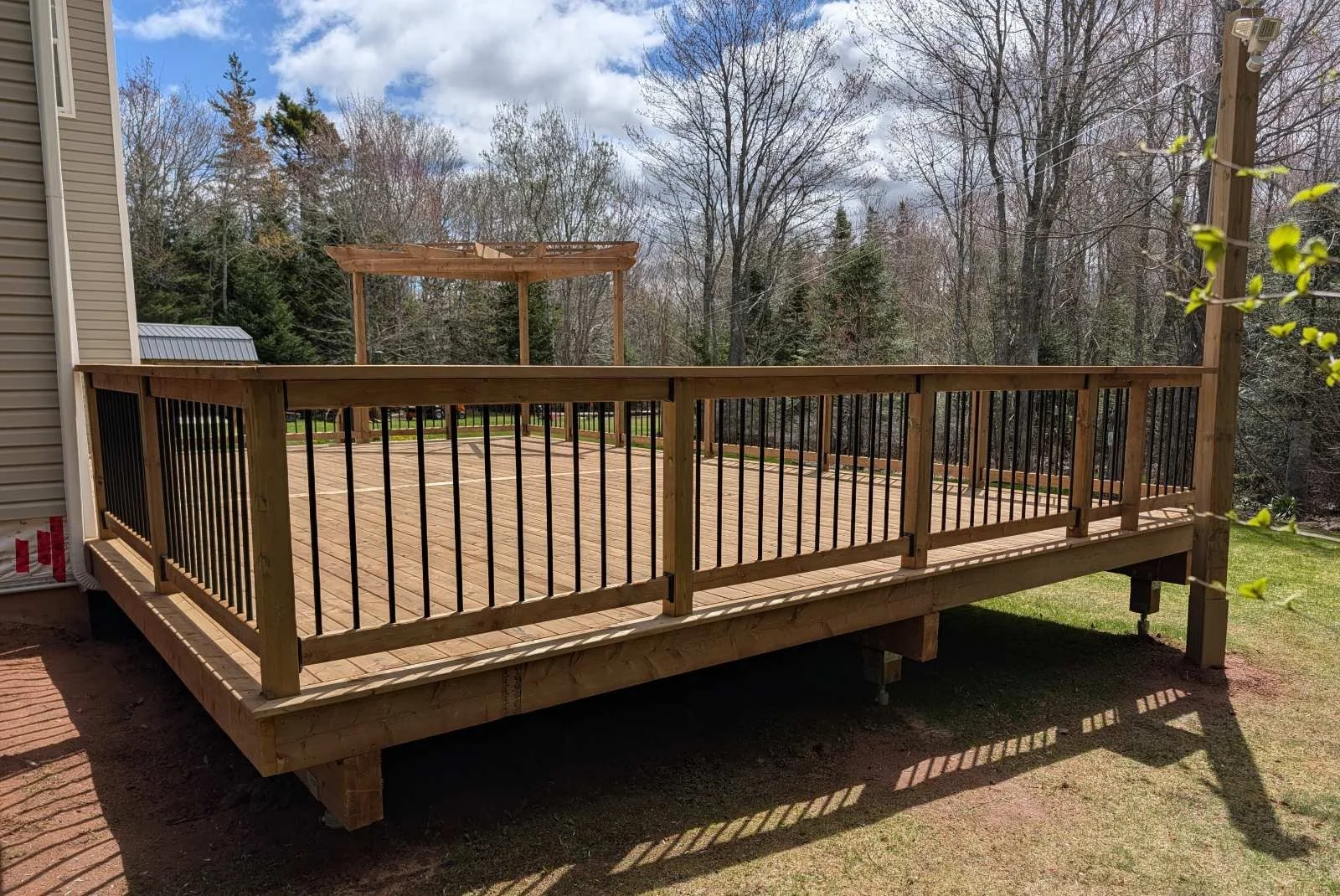 Custom designed and built pressure treated wood and black aluminum railings on deck built for home owner in Brackley Beach, PEI.