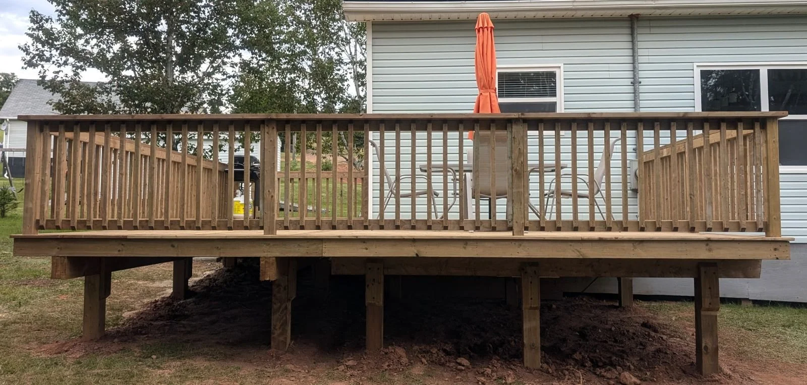 Custom designed and built pressure treated wooden railings on deck built for homeowner in Wild Harbour, PEI.