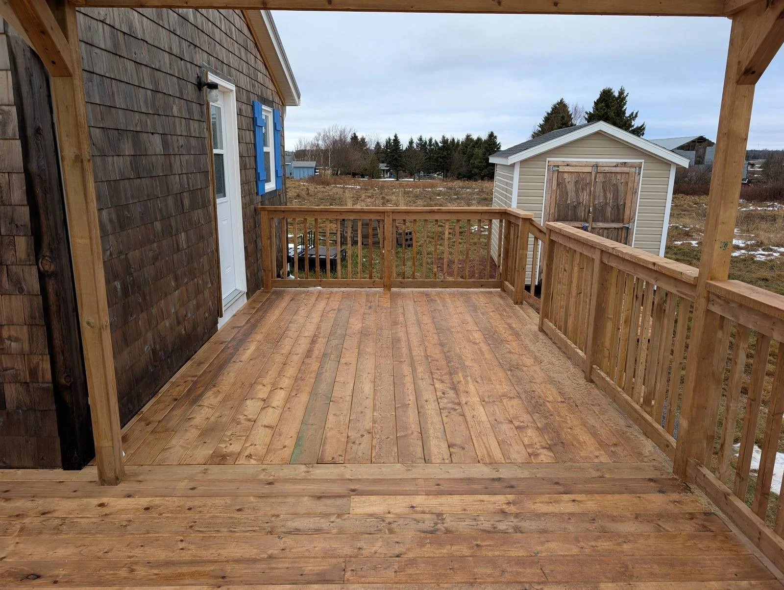 Custom designed and built pressure treated wooden railings on deck built for cottage owner in Canoe Cove, PEI.