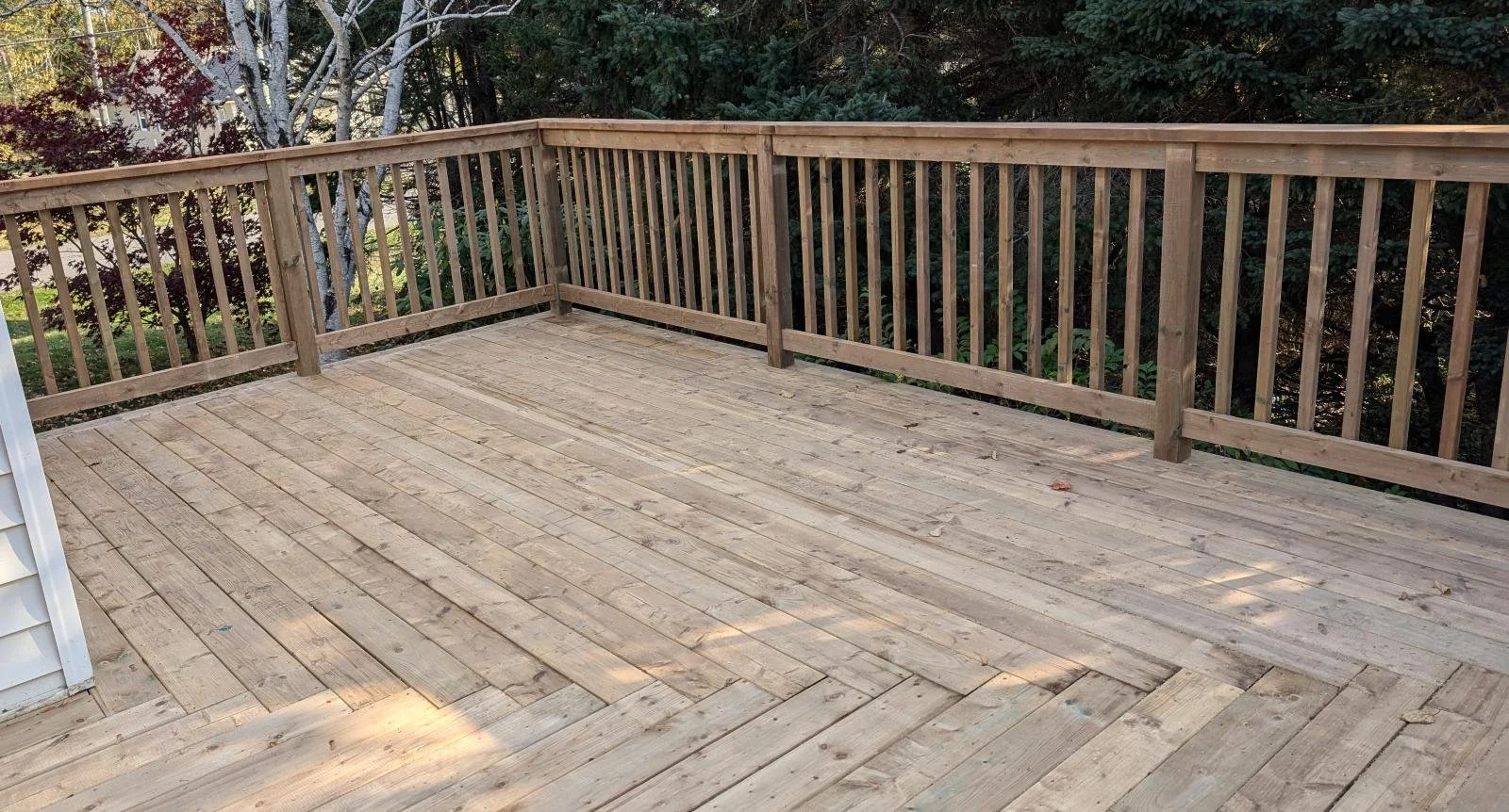 Custom designed and built pressure treated wood railings on upper deck built for homeowner in Stratford, PEI.