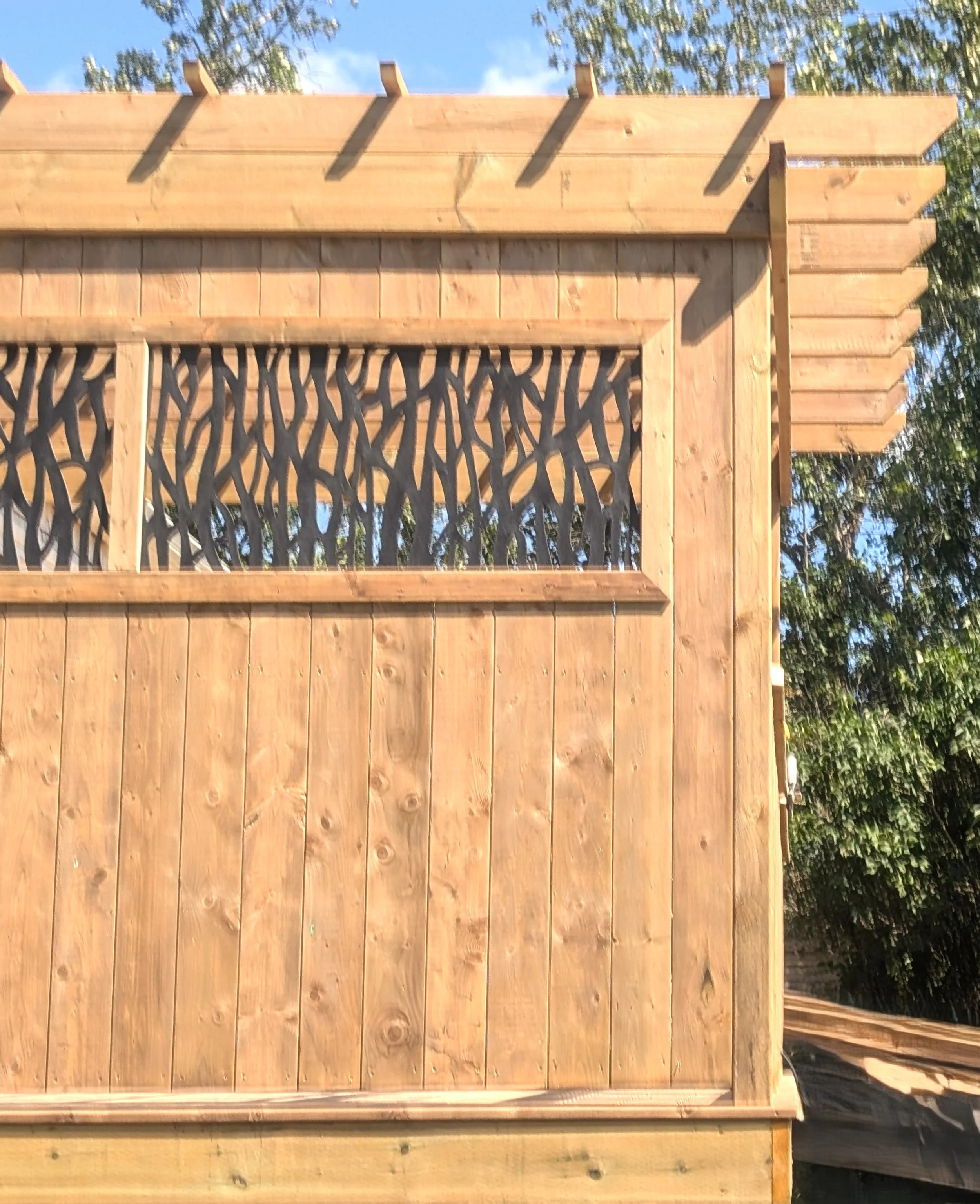 Custom pressure treated wood pergola with privacy insert built for a homeowner in Trout River, PEI 