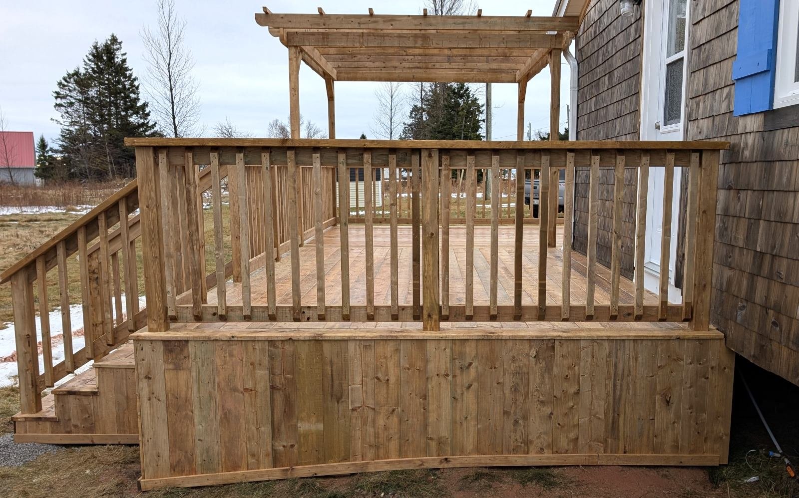Custom designed and built pressure treated wooden railings on deck built for cottage owner in Canoe Cove, PEI.