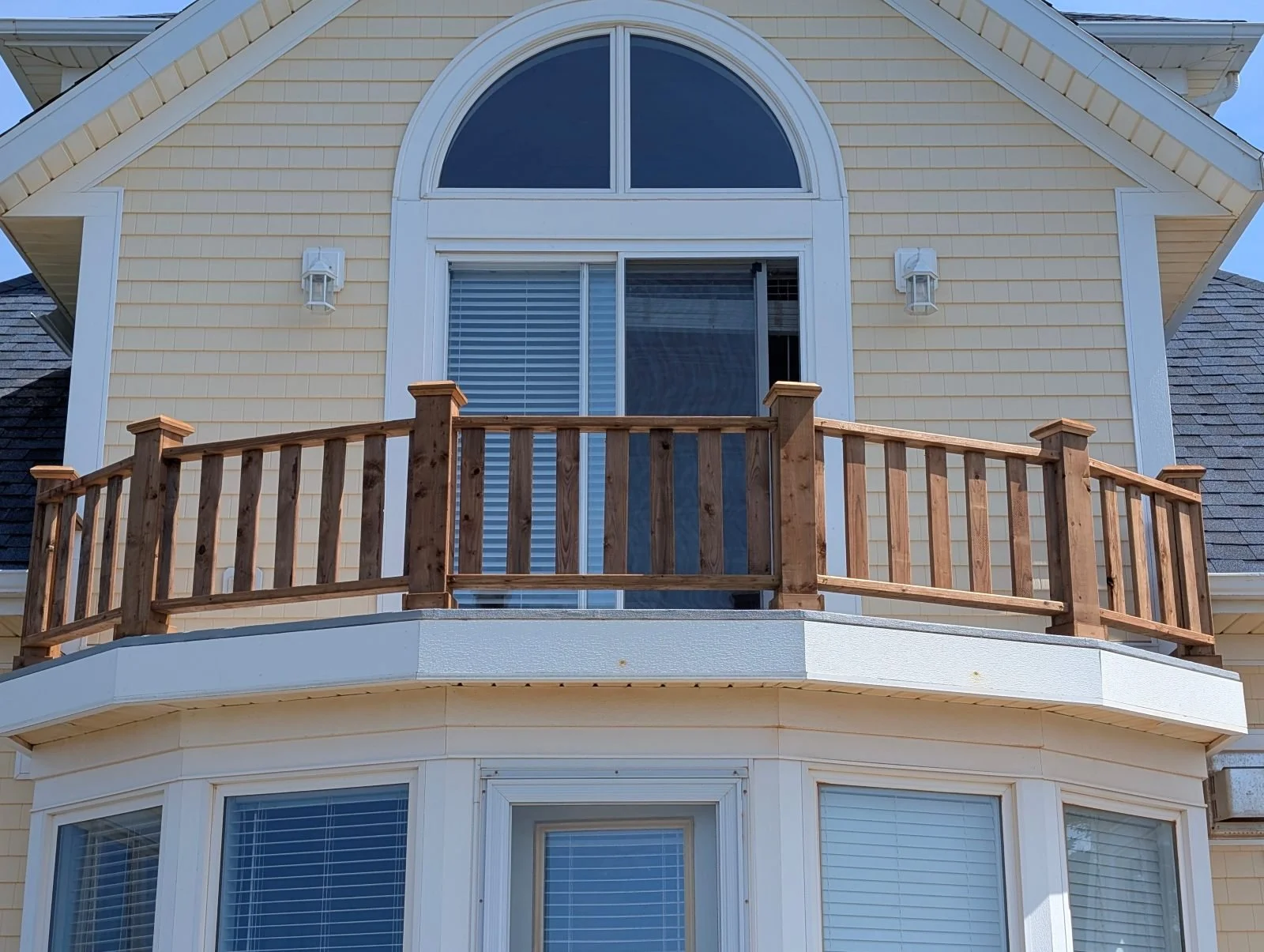 Custom designed and built pressure treated wood railings on upper deck walkout built for cottage owner in Canoe Cove, PEI.