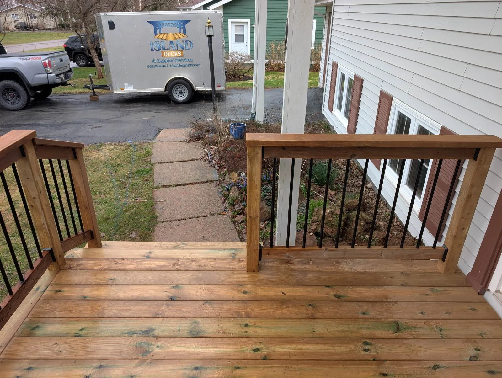 Custom designed and built pressure treated wood and black aluminum railings on deck built for home owner in Charlottetown, PEI.