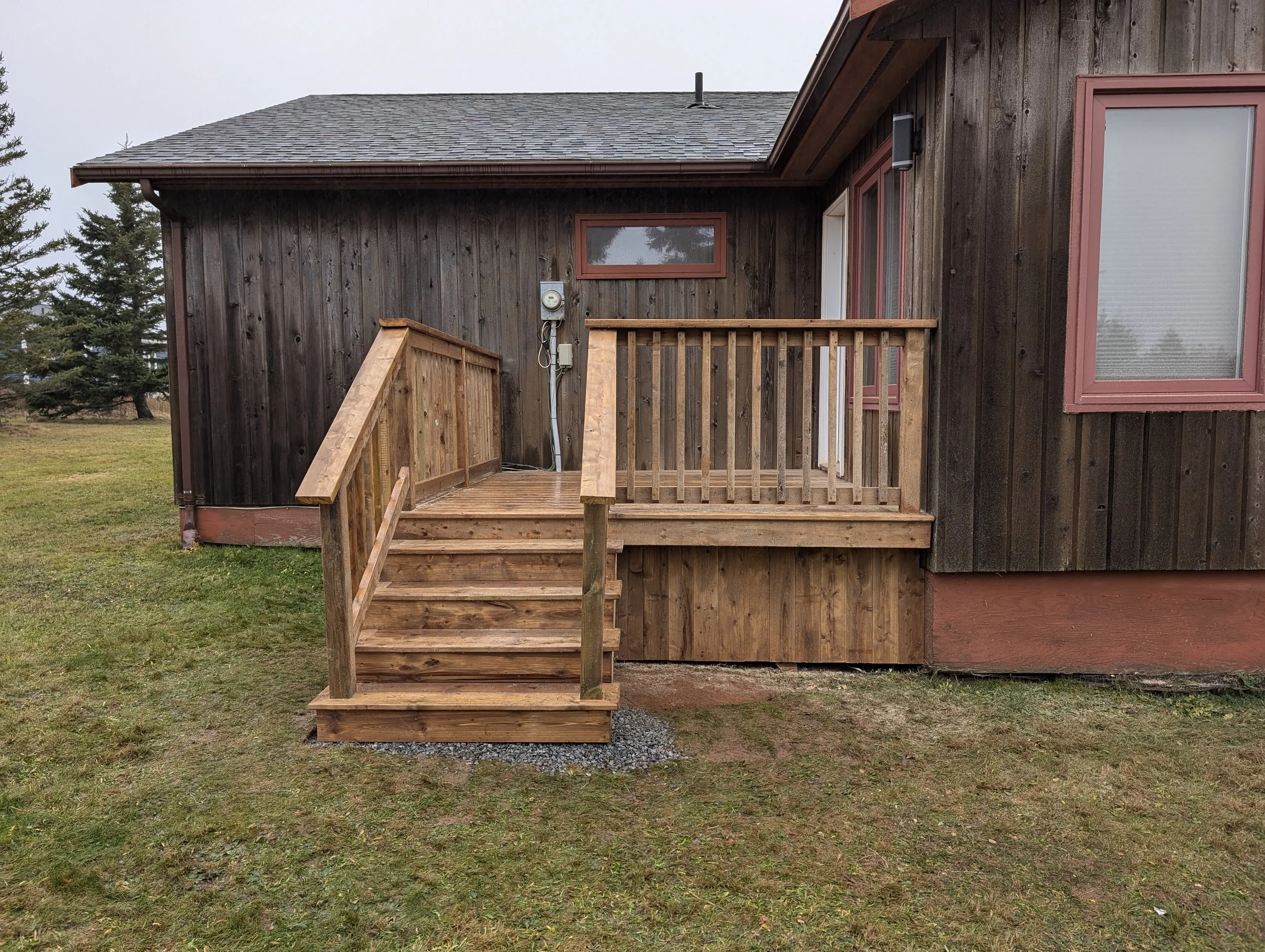 Custom designed and built pressure treated wood railings on deck for cottage owner in Stanley Bridge, PEI.