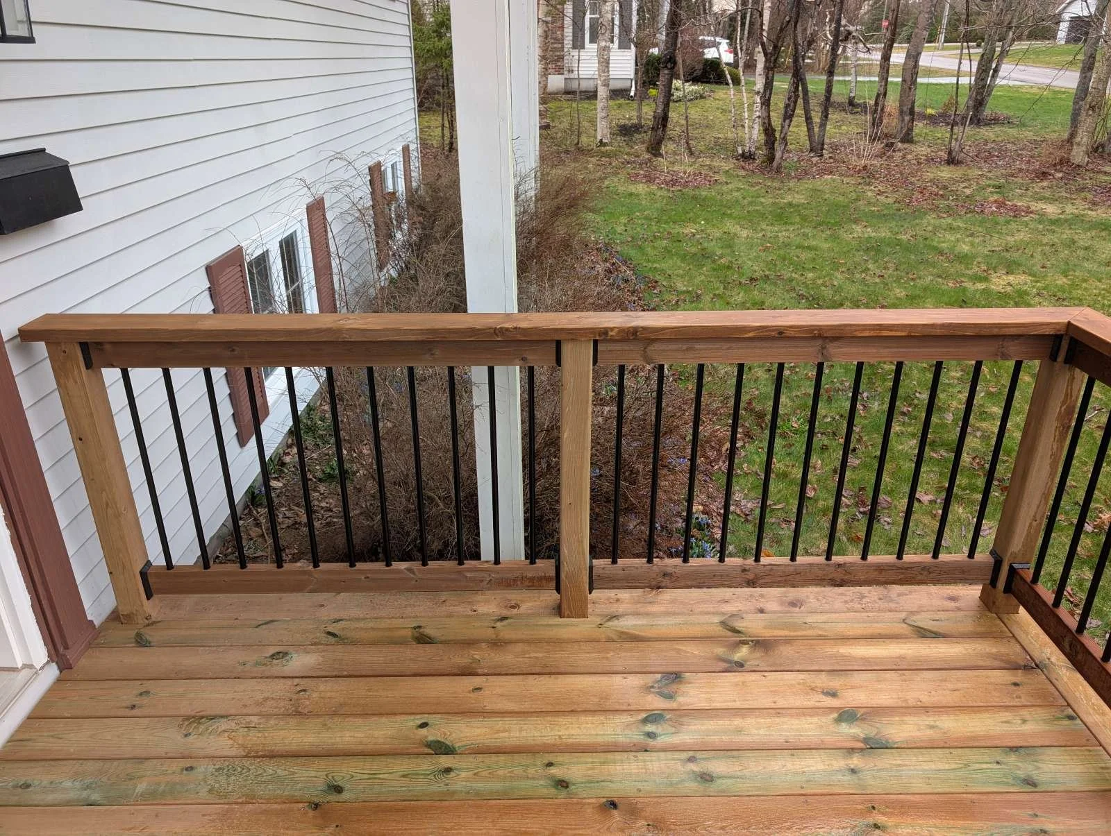 Custom designed and built pressure treated wood and black aluminum railings on front step built for home owner in Charlottetown, PEI.